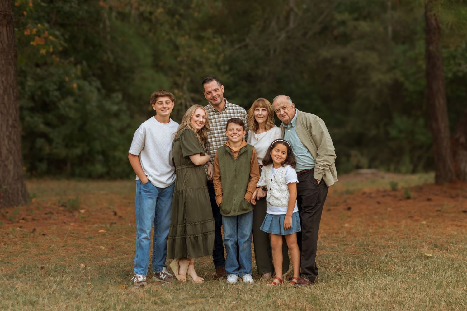 A beautiful family of seven. A mom and dad, a grandma and grandpa posing with a 10 year old son and 16 year old son and 8 year old niece.