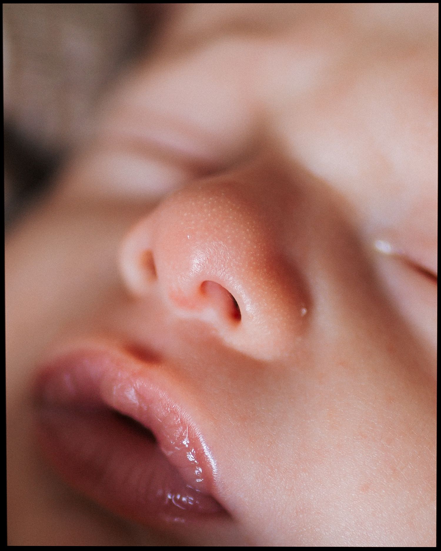 Extreme close-up of a peaceful sleeping newborn baby's nose and lips.