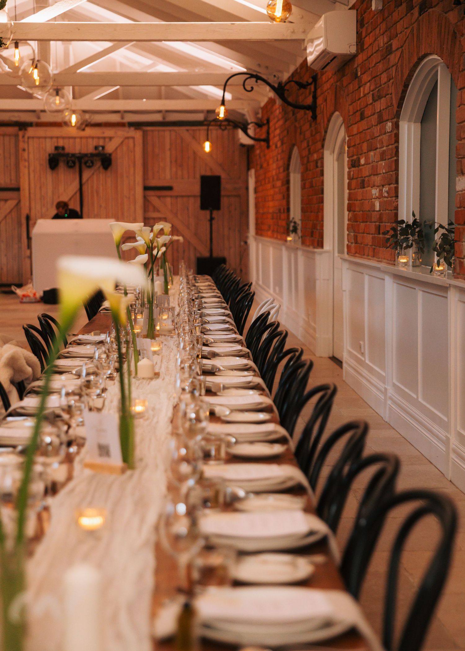Elegant long reception table set with candles and white florals.