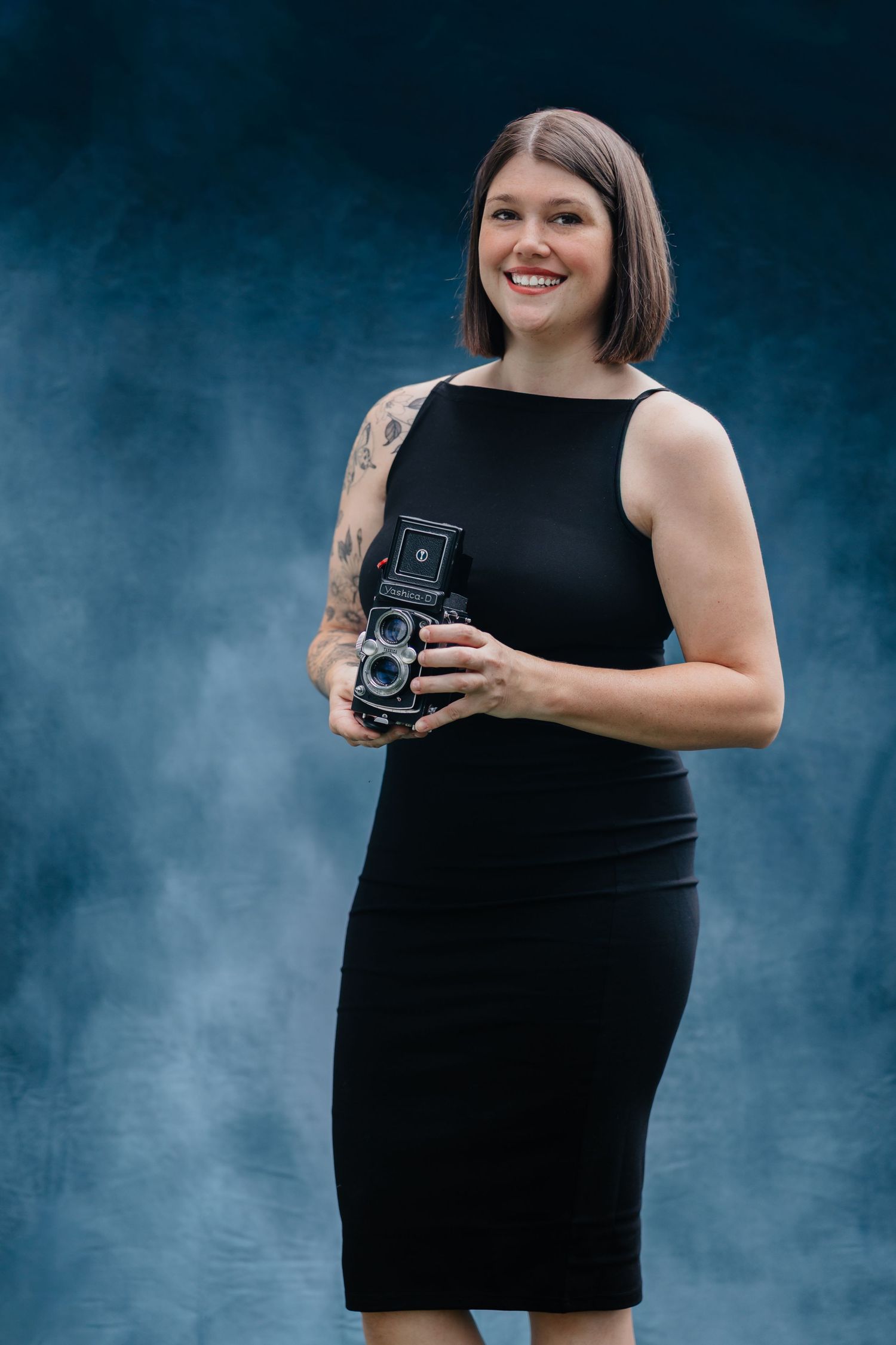 Haley, a luxury wedding photographer in the Lehigh Valley Wedding Industry holding a Film Camera