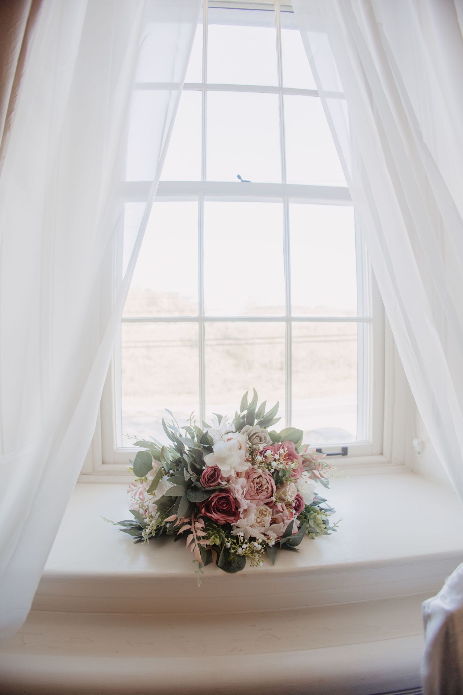Bridal bouquet close-up in window with pastel florals in Bethlehem PA, styled fine art editorial wedding image