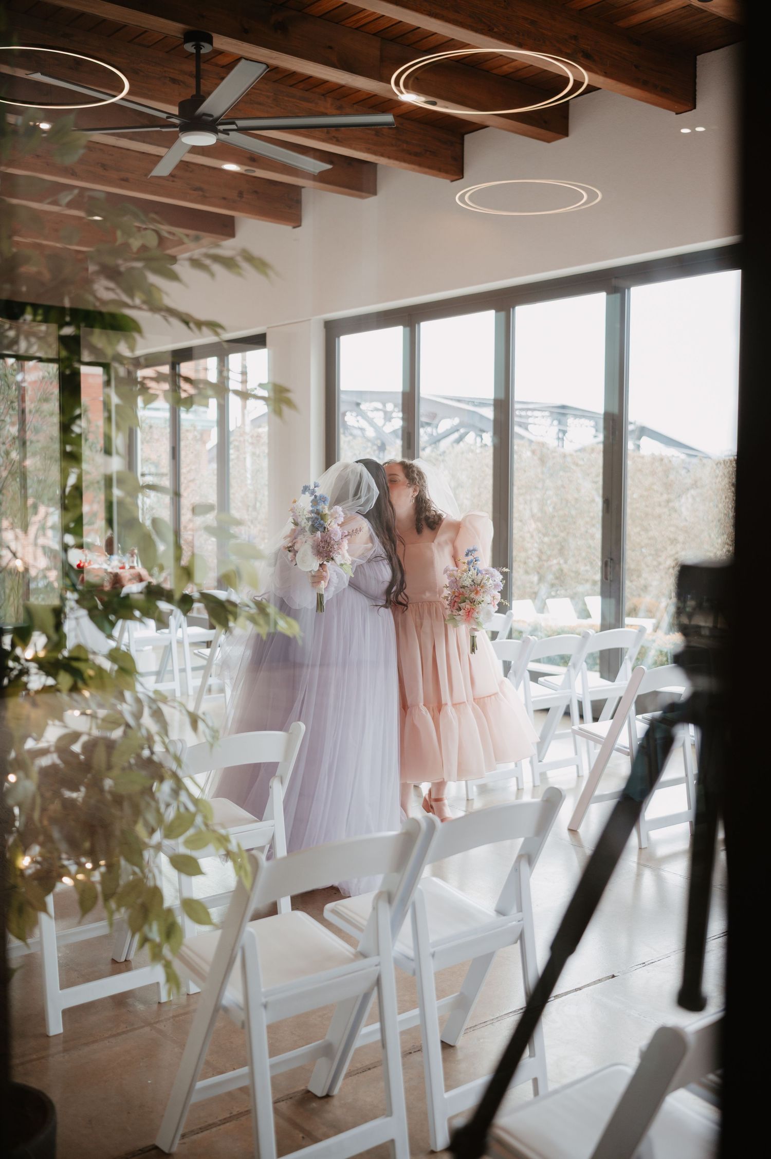 Brides shares tender moment inside modern wedding venue. LGBTQ wedding photographer in Eastern PA