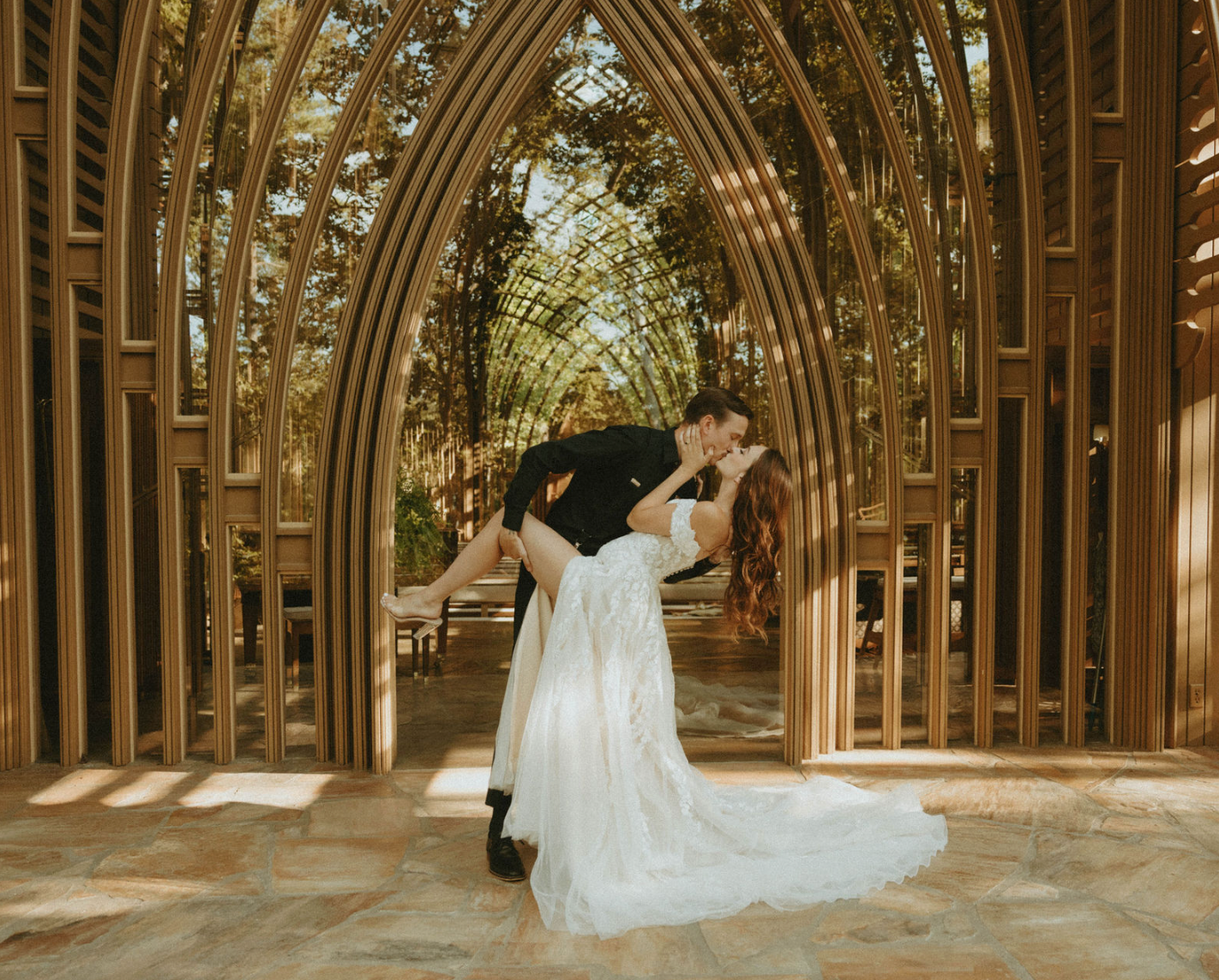 Editorial photo of wedding couple kissing in front of chapel