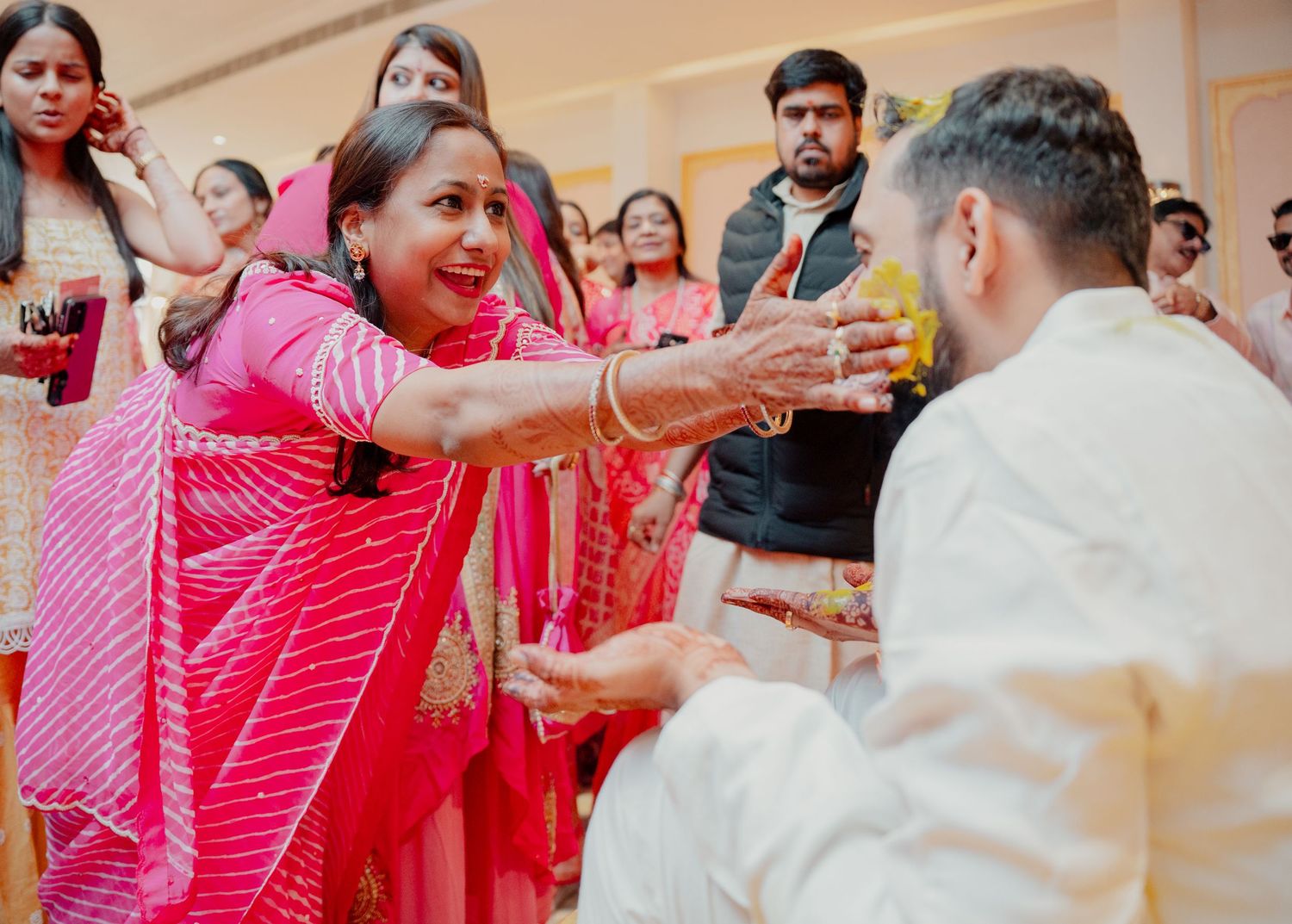 Woman in pink saree performing traditional ritual with man in white at vibrant Indian wedding ceremony in Eastern PA