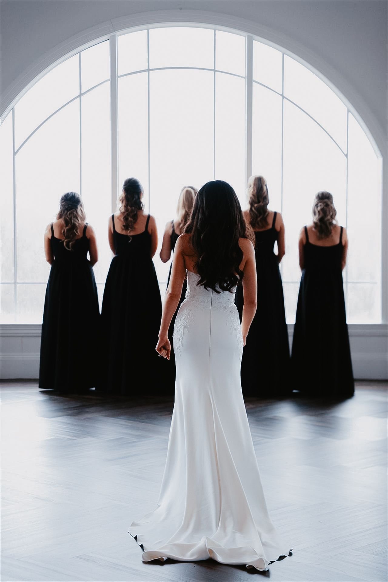 Joyful first look with bridesmaids at an upscale Bethlehem, PA wedding. the bride glows in soft natural light as her girls react.