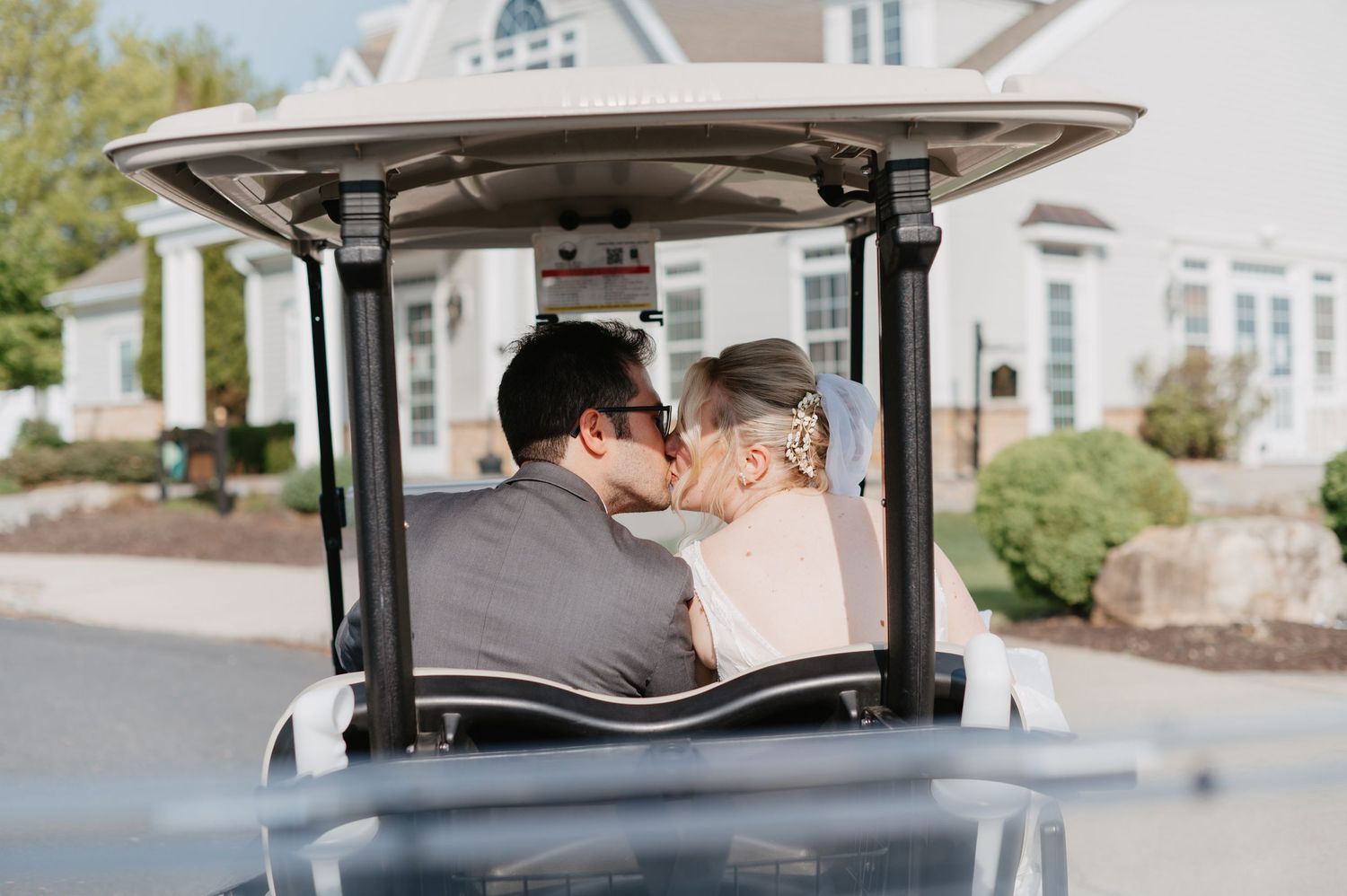 Documentary photograph of bride and groom in a golf cart from behind in Easton, PA