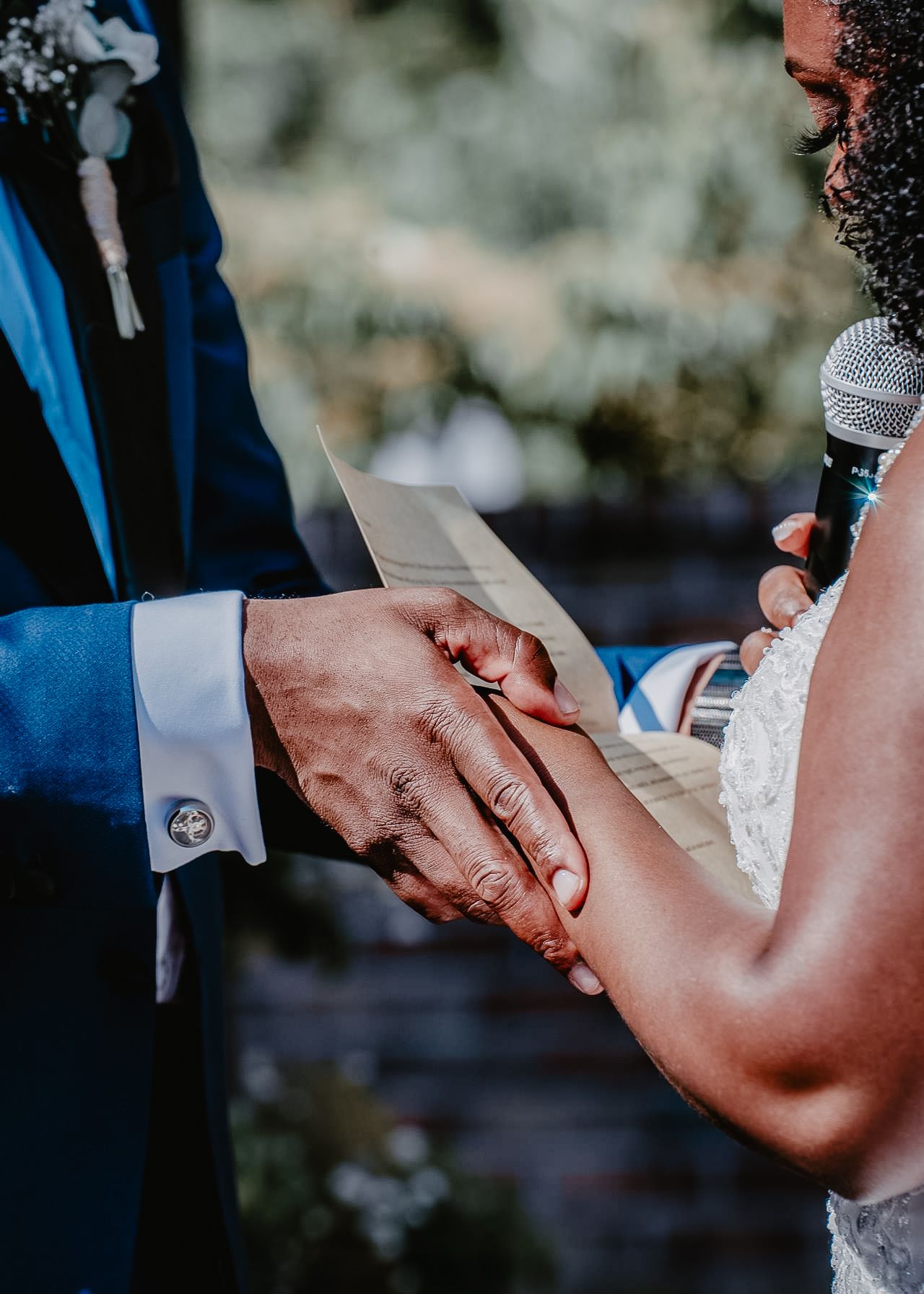 Black Bride and Groom at Alter of Wedding detail shot of them holding hands and reading vows in the Poconos, Pennsylvania