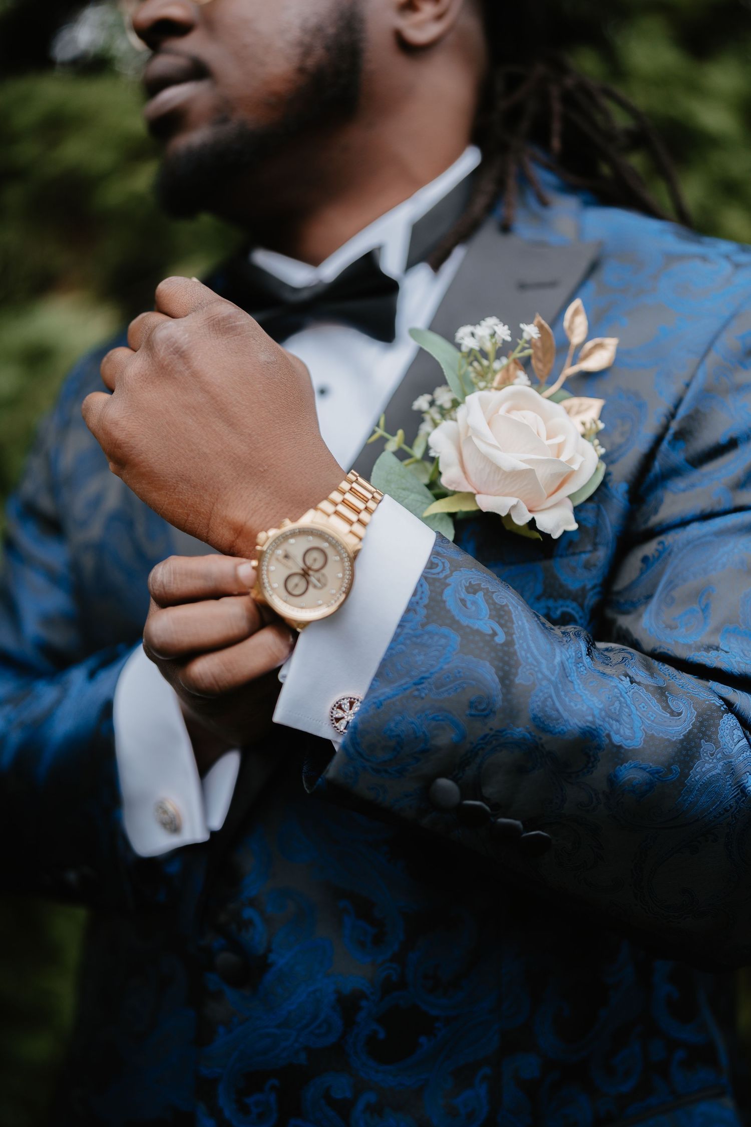 Groom in blue floral tuxedo adjusting gold watch cufflink with white rose boutonniere at wedding.Film Photography Lehigh Valley