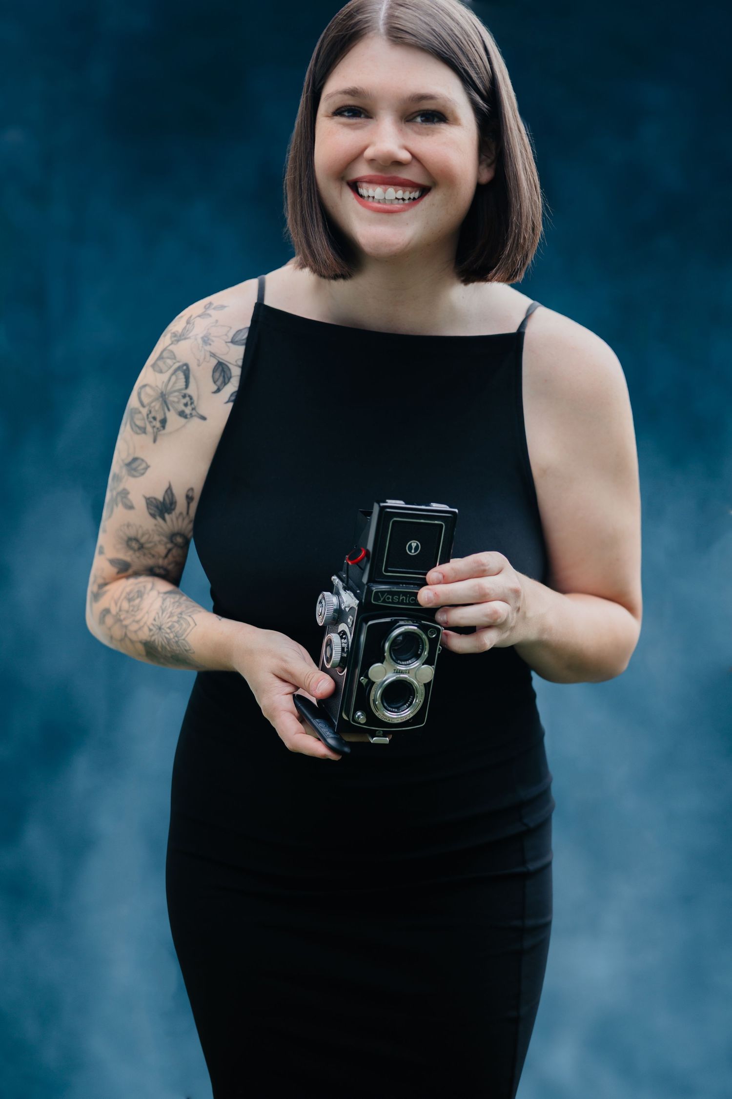 Haley Brown, owner of Rosewater Photography, holding a film camera for an editorial portrait in Philadelphia.
