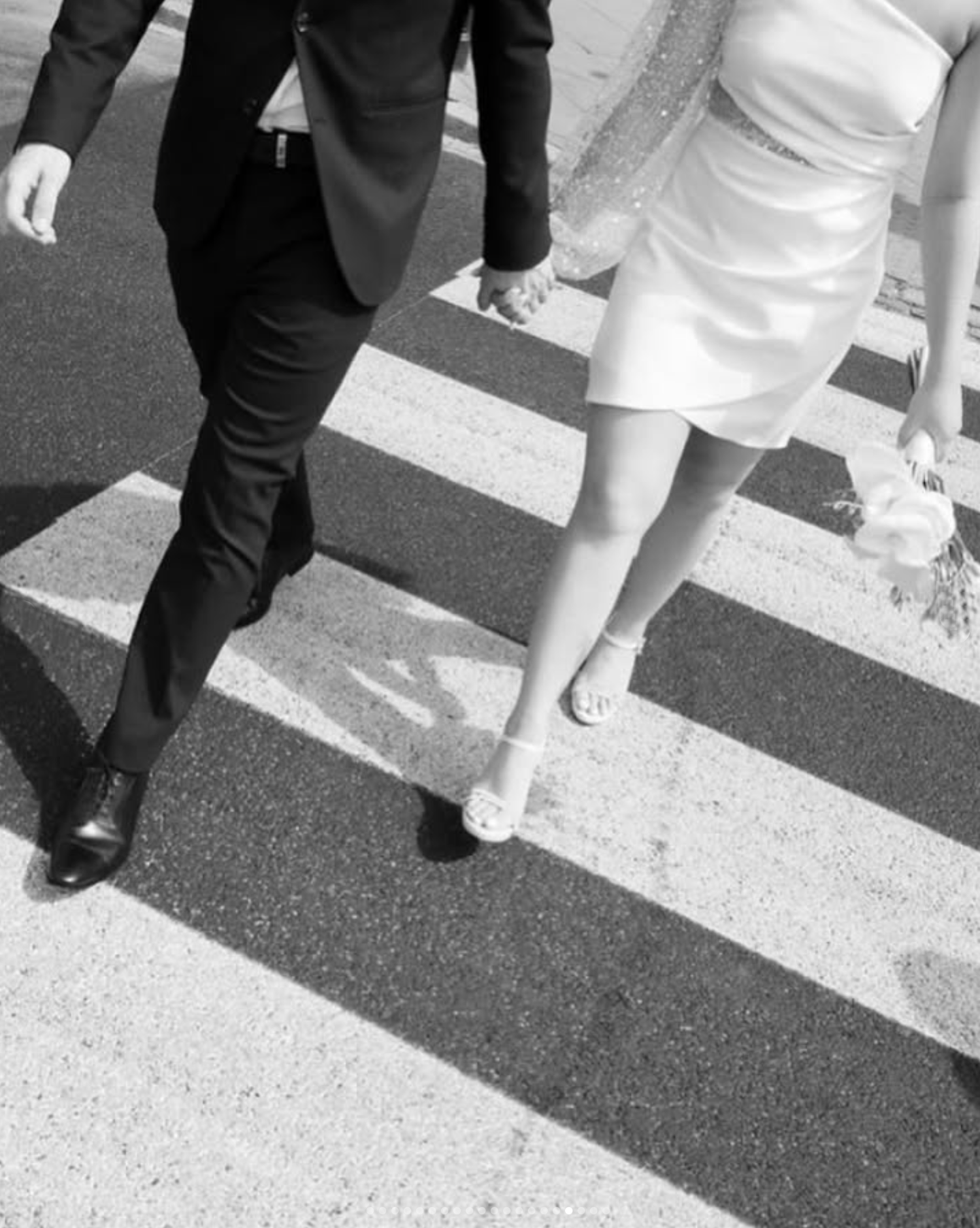 Black and white photograph of formal wedding party feet walking in sequence.