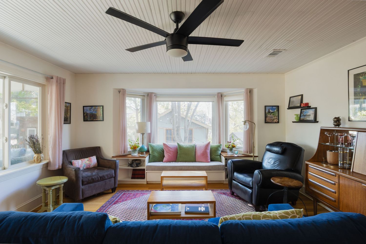 Bright living space featuring bay window with built-in seating and mix of modern and traditional furniture.