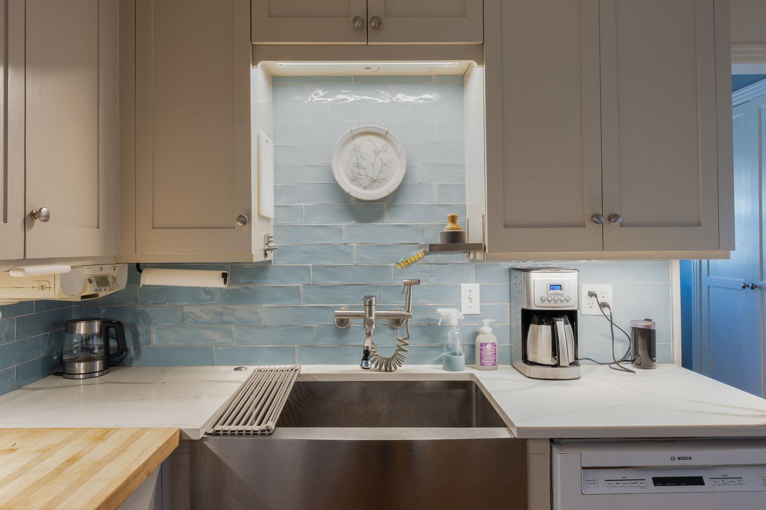 Kitchen with subway tile backsplash, stainless appliances, and light wood countertops.