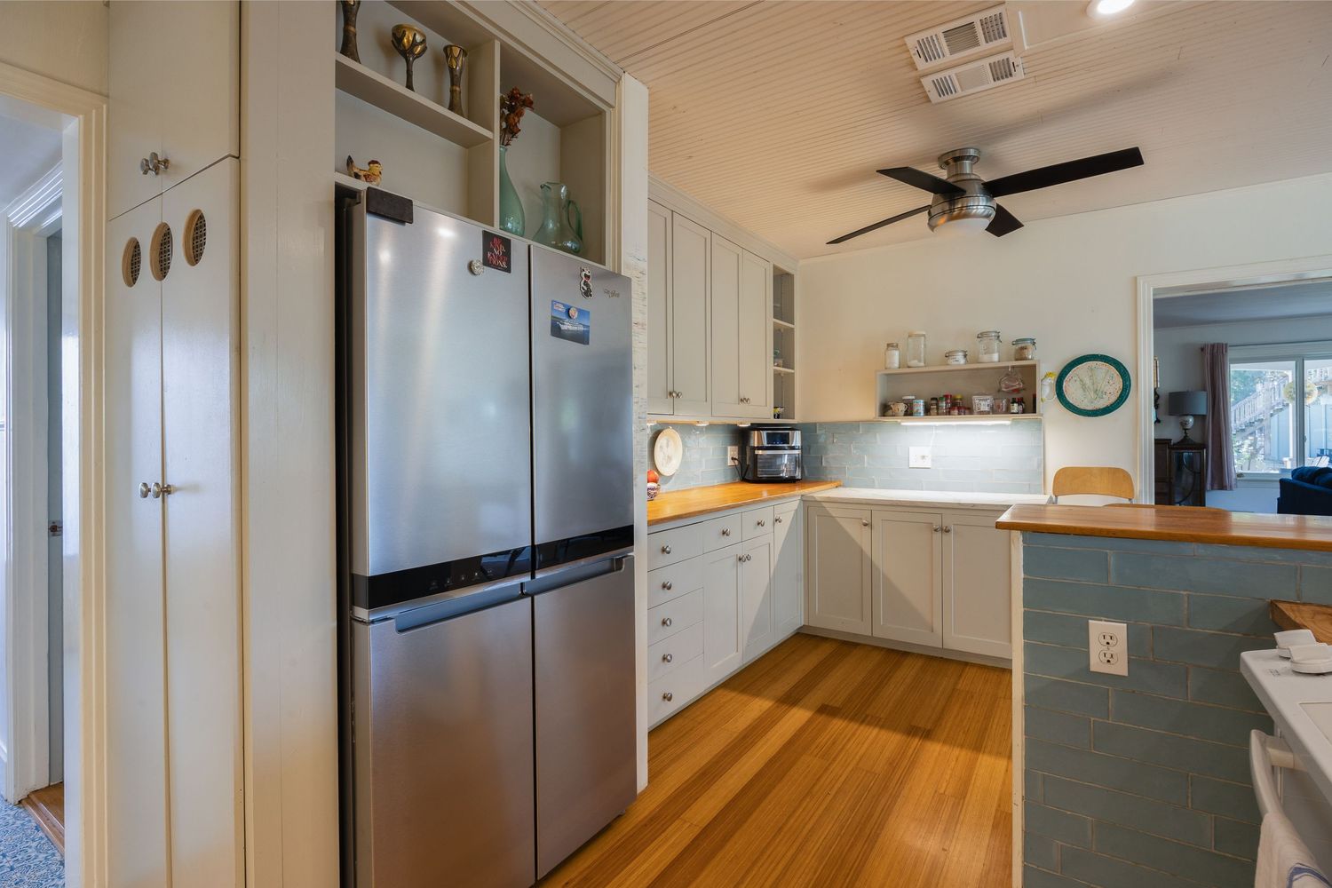 Contemporary kitchen layout with ceiling fan and stainless steel appliances.