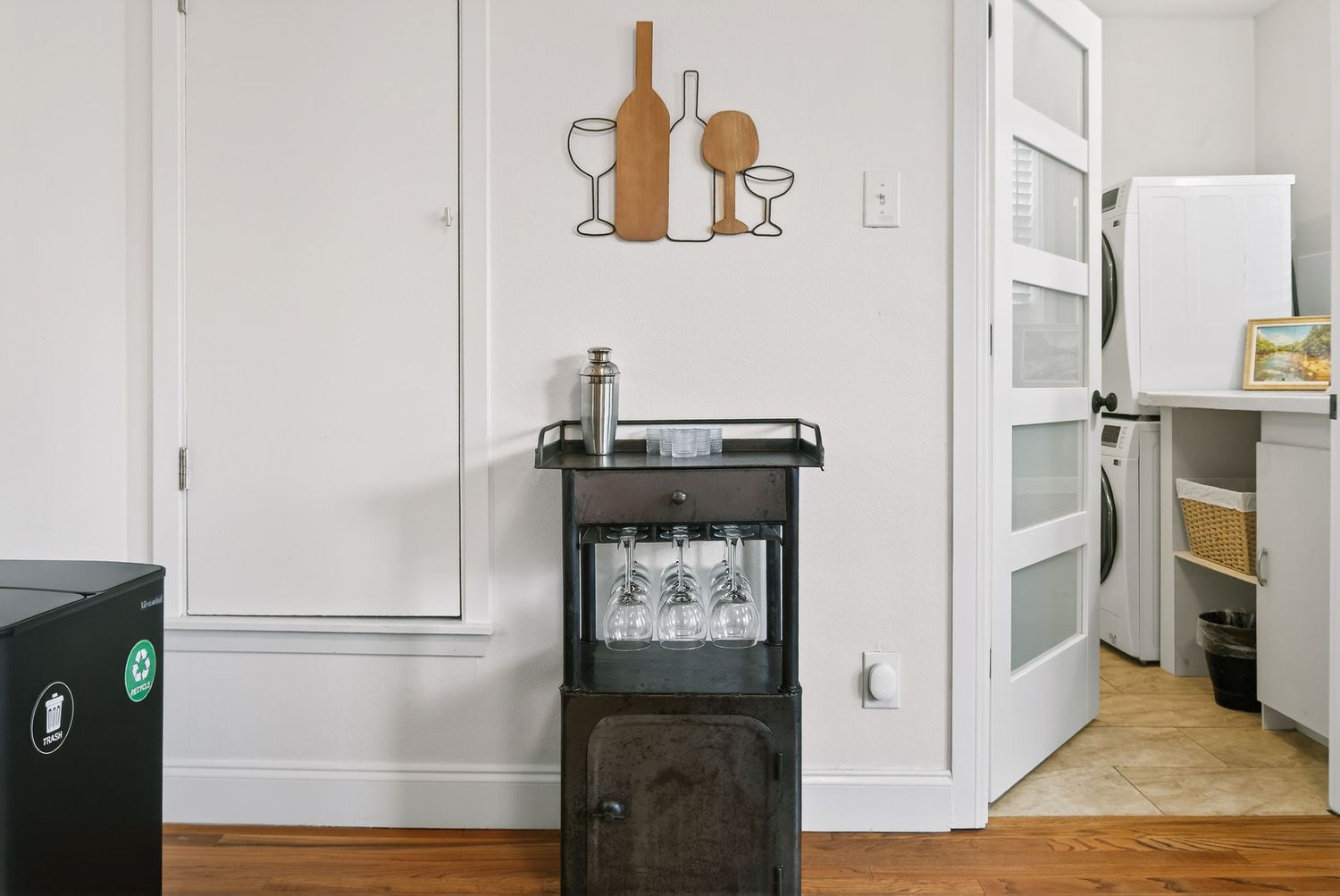 Modern wine storage cabinet with glasses displayed in a minimalist white room interior.