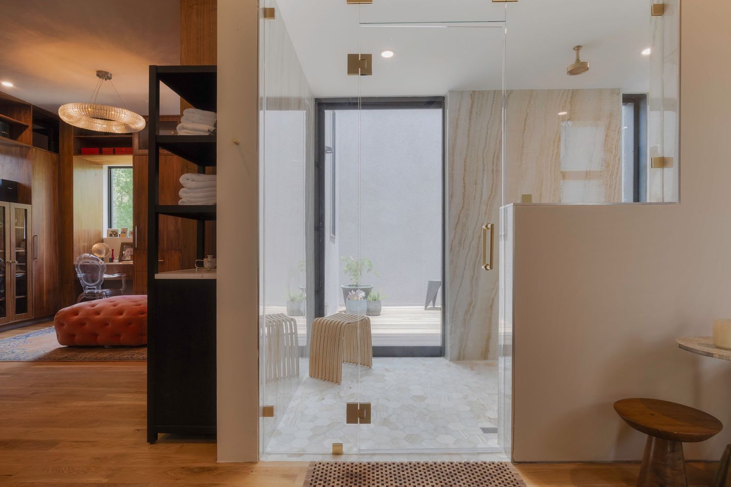 Modern bathroom entrance with glass doors, wooden floors, and minimalist design elements.