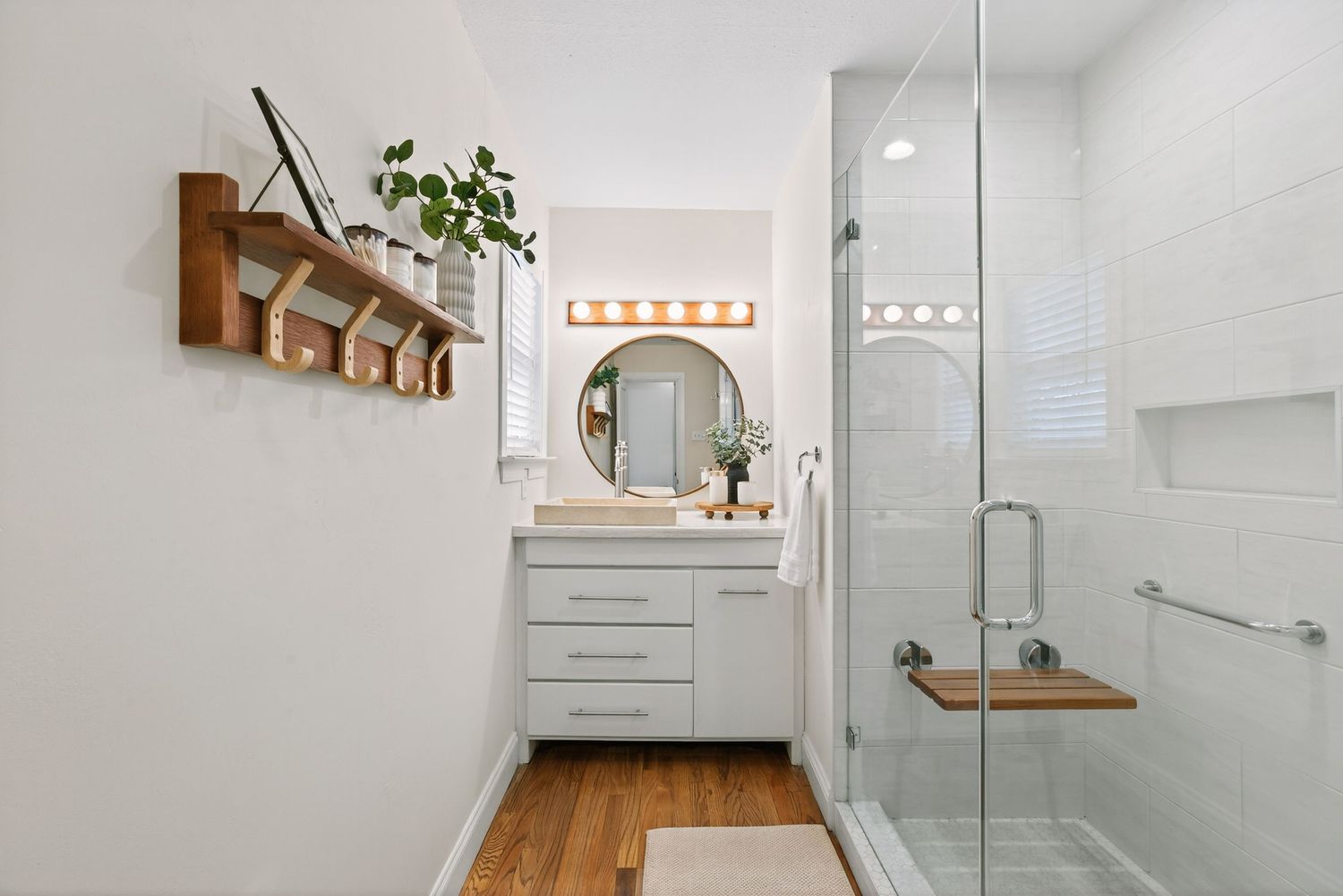 Modern bathroom renovation features floating vanity, glass shower enclosure, and wood accents for a spa-like feel.