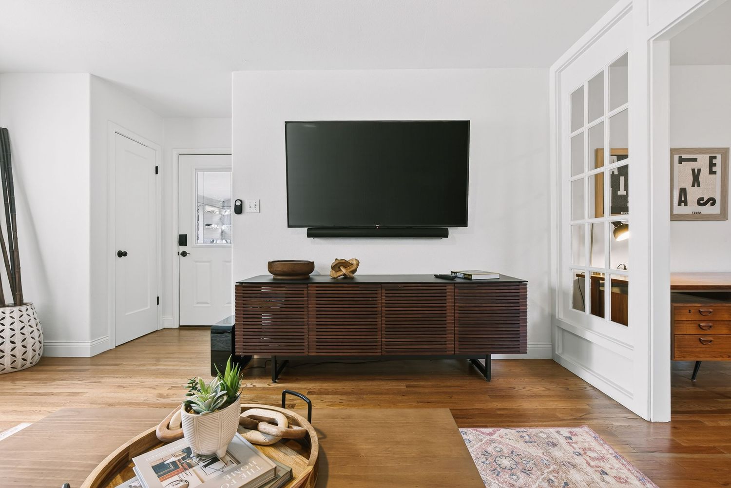 Modern white interior design with hardwood flooring and minimalist decor in an open concept living space.