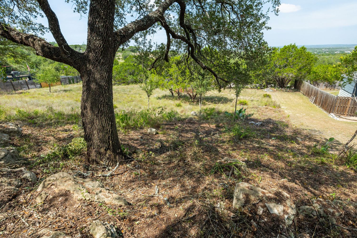 Scenic Texas Hill Country lot with mature oak trees, natural landscaping, and expansive views of rolling terrain.