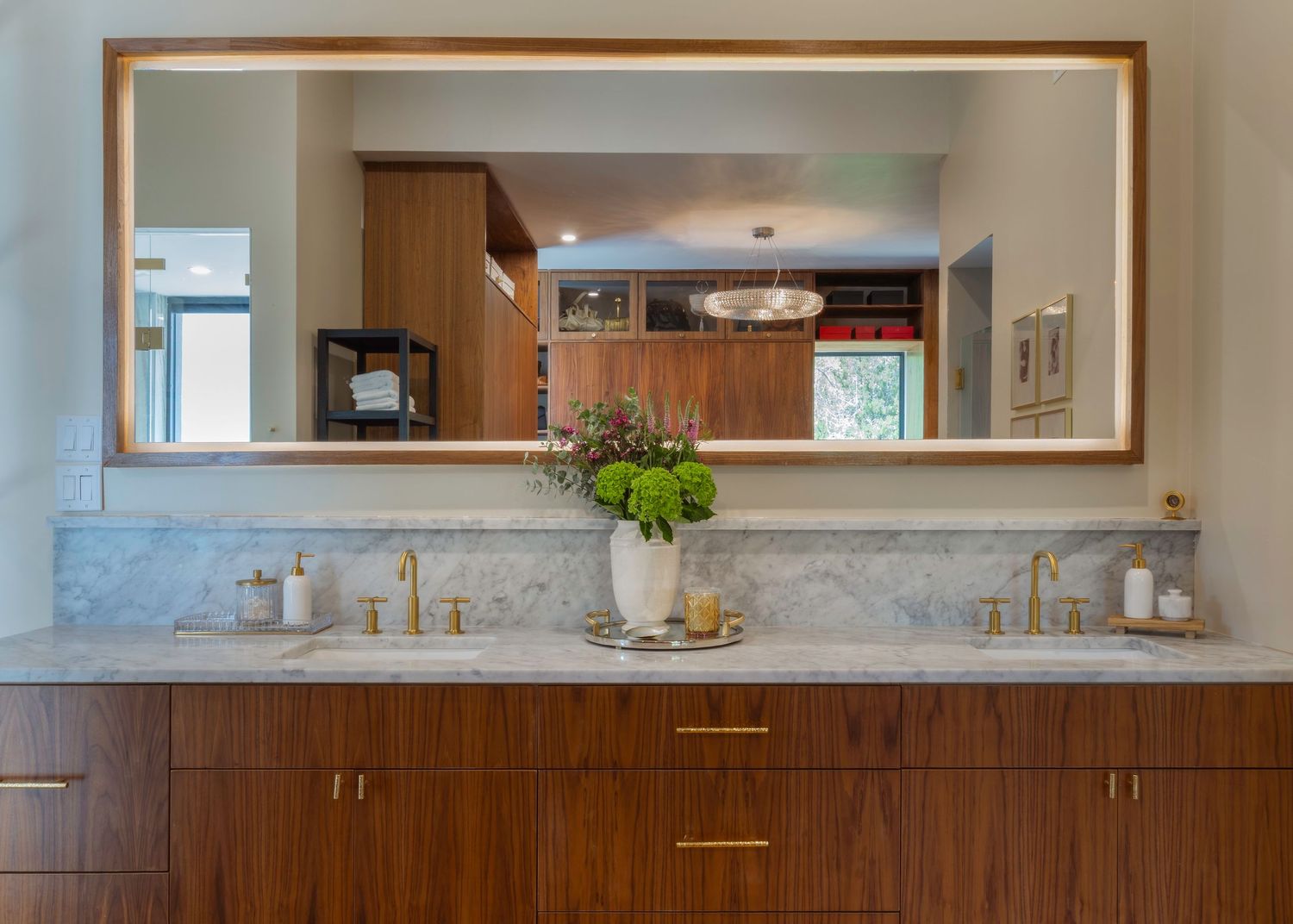 Modern kitchen interior with wood cabinets and marble countertops extending along the wall.