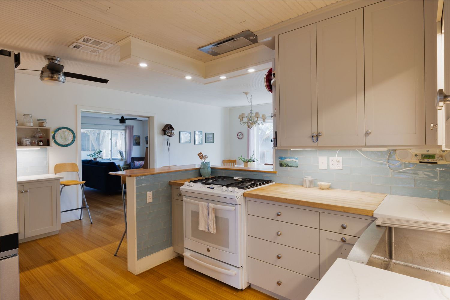 Spacious kitchen featuring white cabinetry and wooden countertops with natural lighting.