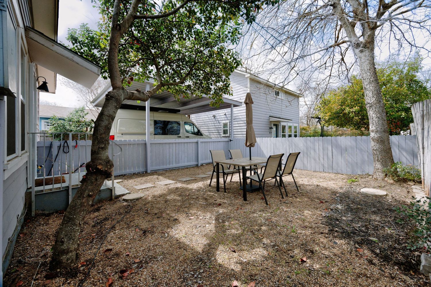 Panoramic view of a backyard landscaping project showing dirt mounds and construction work in progress.