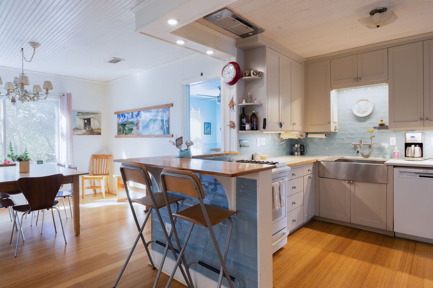 Open concept kitchen and dining area with hardwood floors and white cabinetry.