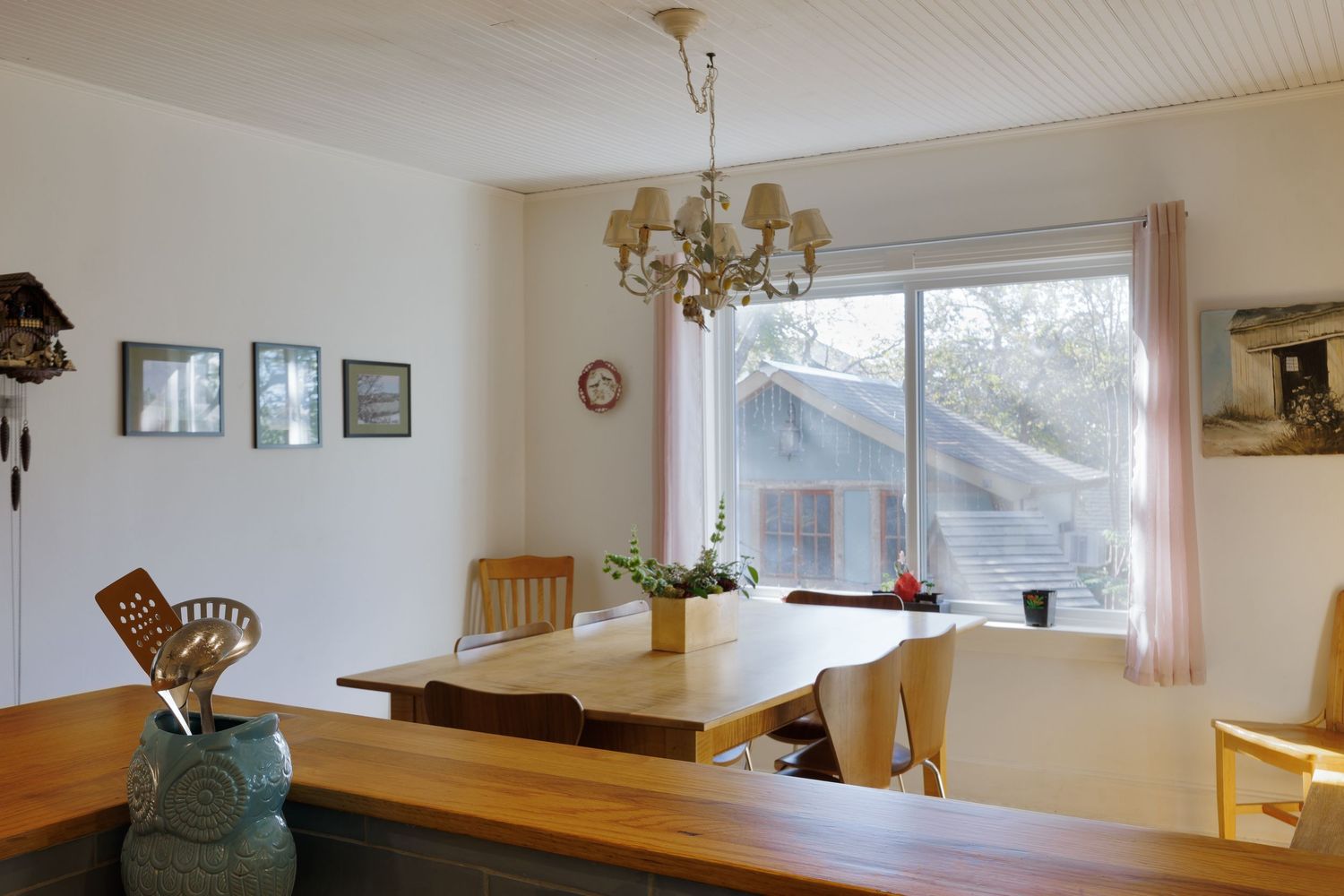 Panoramic view of open concept kitchen and dining space with large windows.