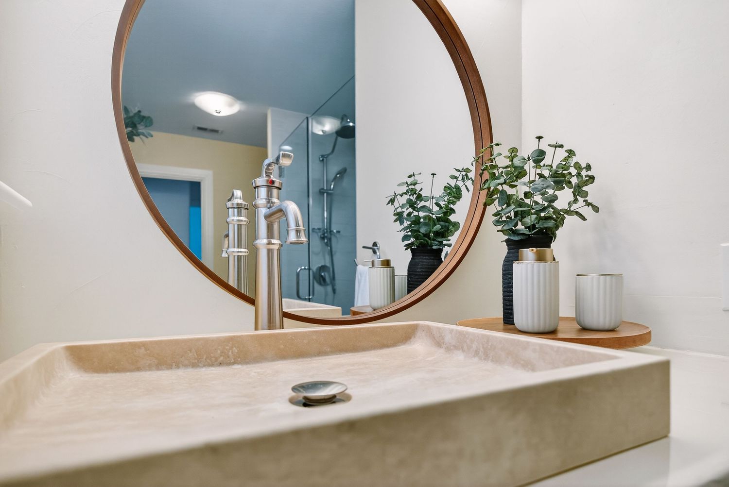 Modern bathroom interior with round mirror, concrete sink, and minimalist design elements creates a sleek aesthetic.