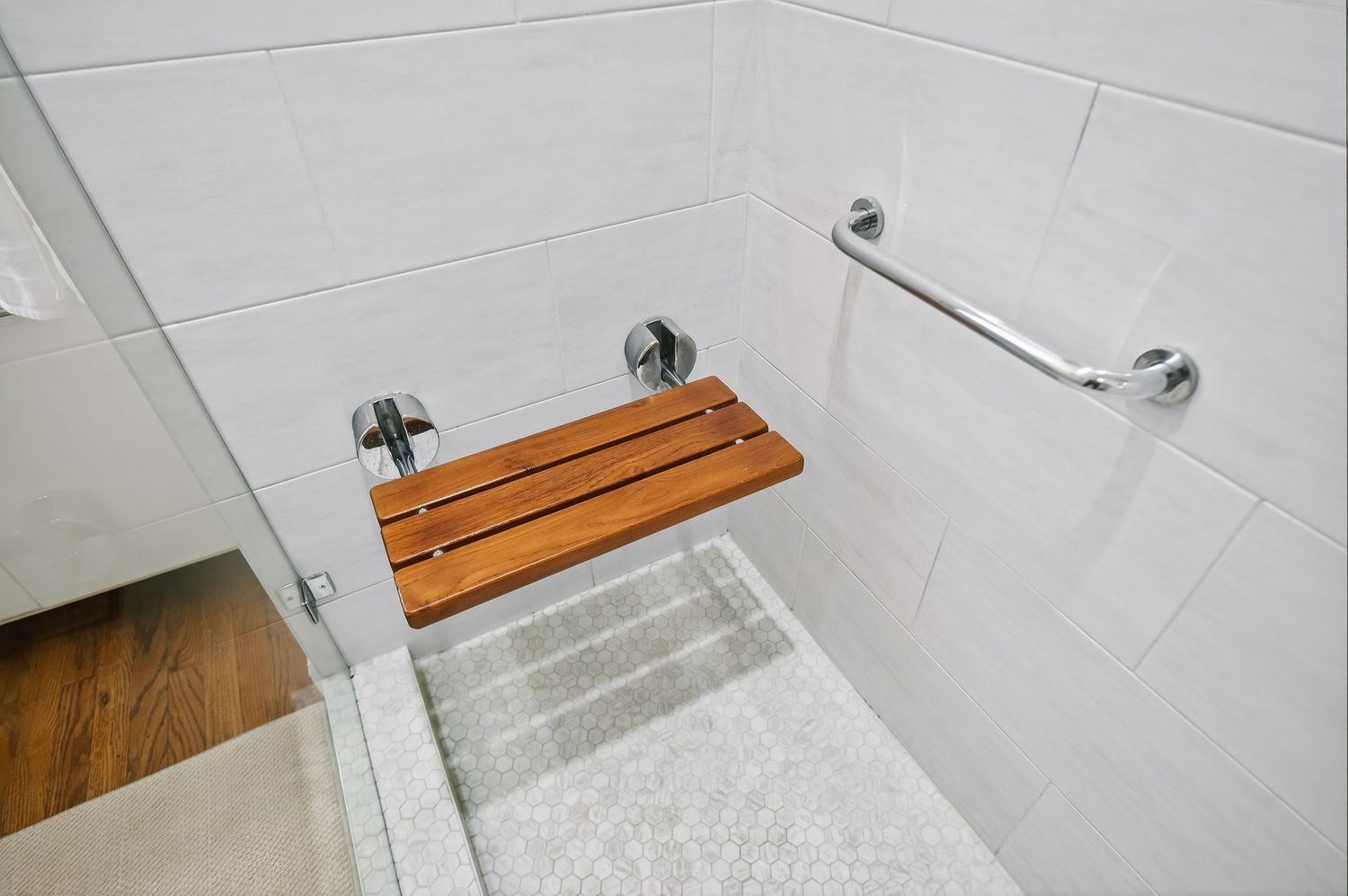 A white bathroom vanity with wood countertop shown in various stages of installation against a tiled wall.