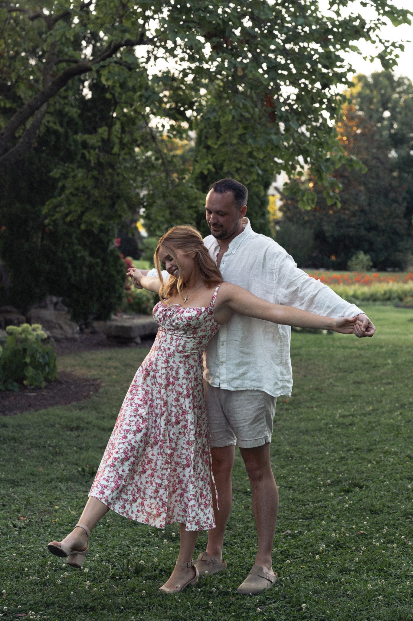 A couple dances playfully in Centennial Park during sunset in summertime.