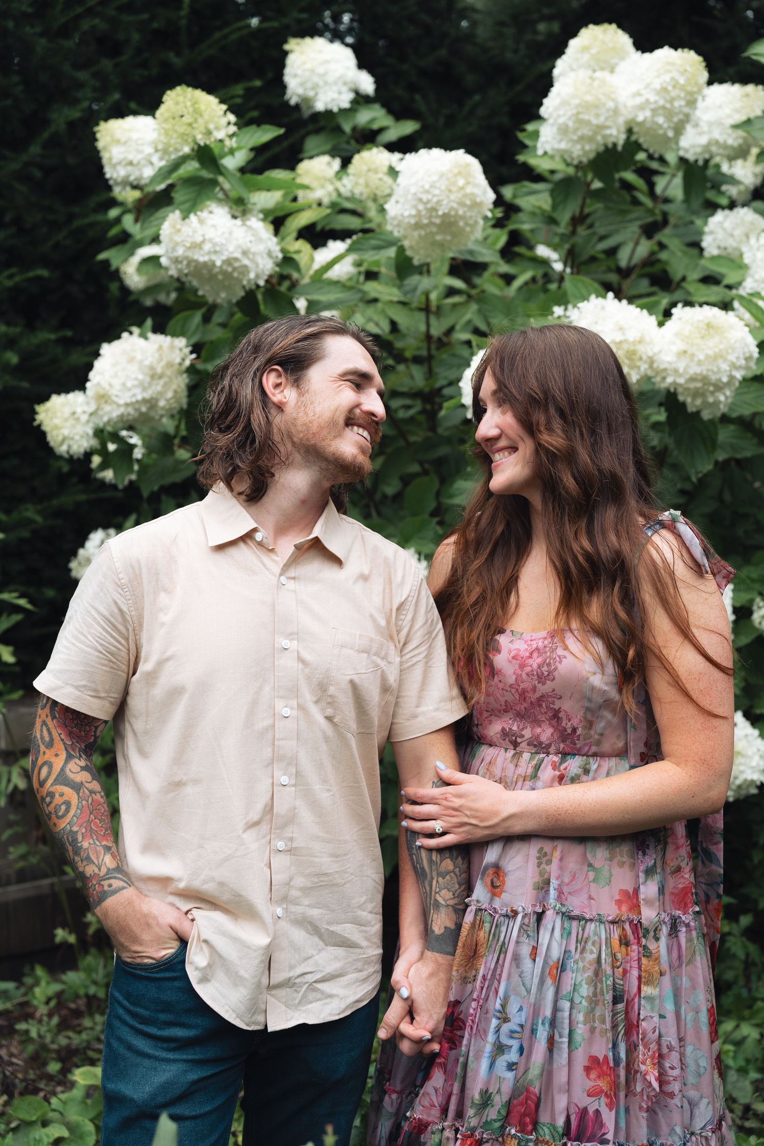 Romantic garden with white hydrangea flowers showing a couple sharing joyful laughter and tender moments in Indianapolis