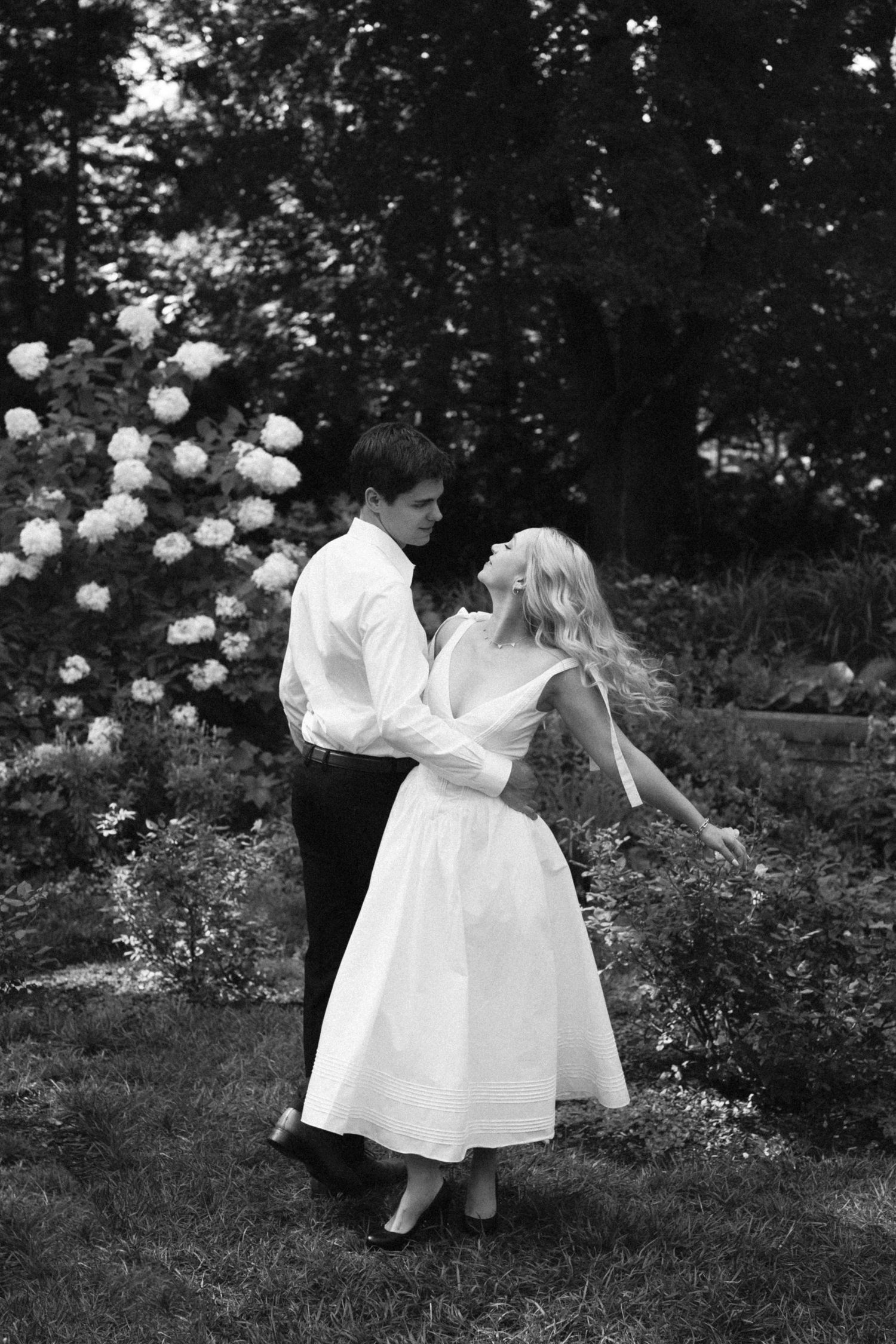 Three black and white vintage photographs show children in white dresses playing with balloons in a garden setting.