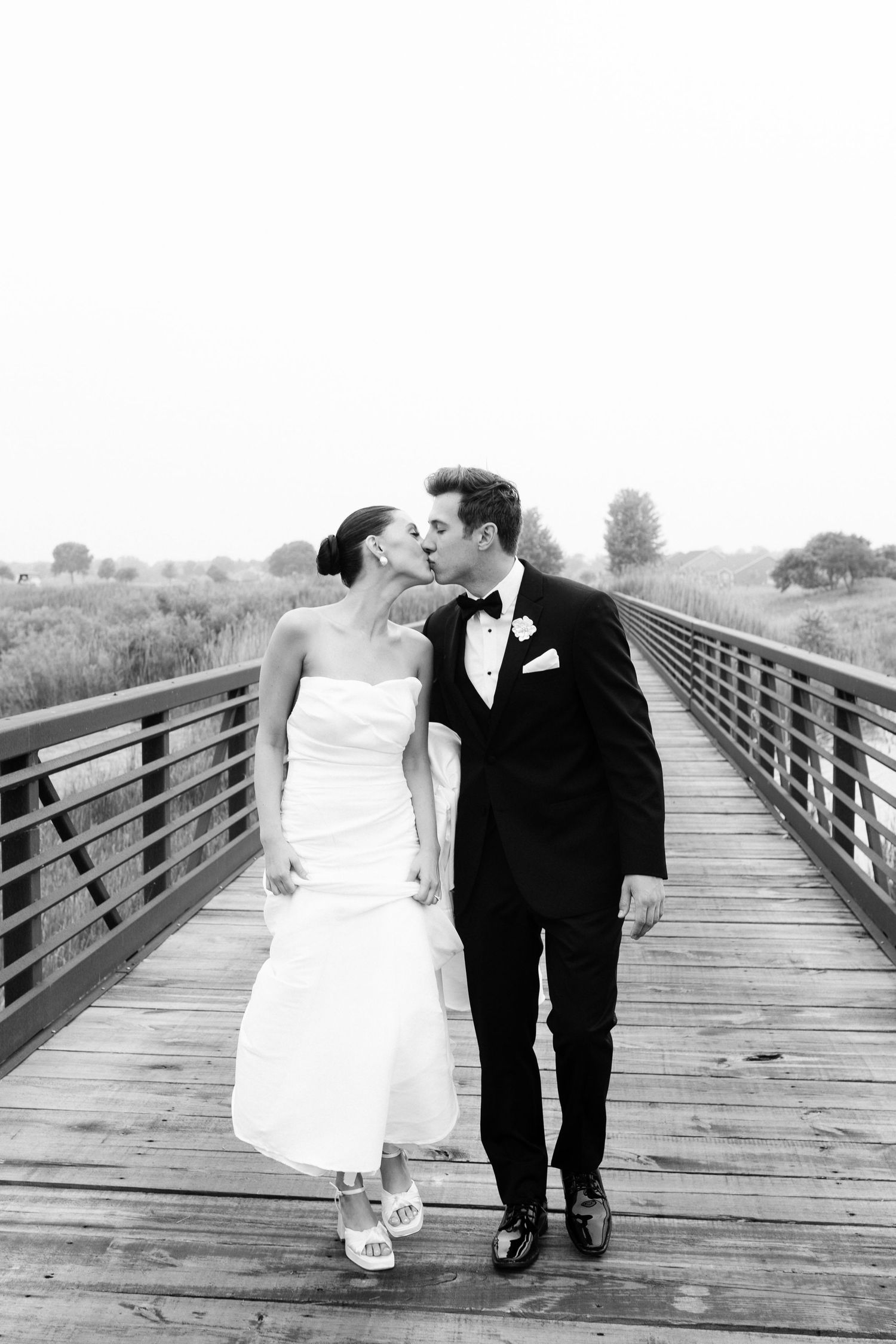 Romantic black and white wedding photo of a couple sharing an intimate moment on a wooden boardwalk in Chicago, Illinois