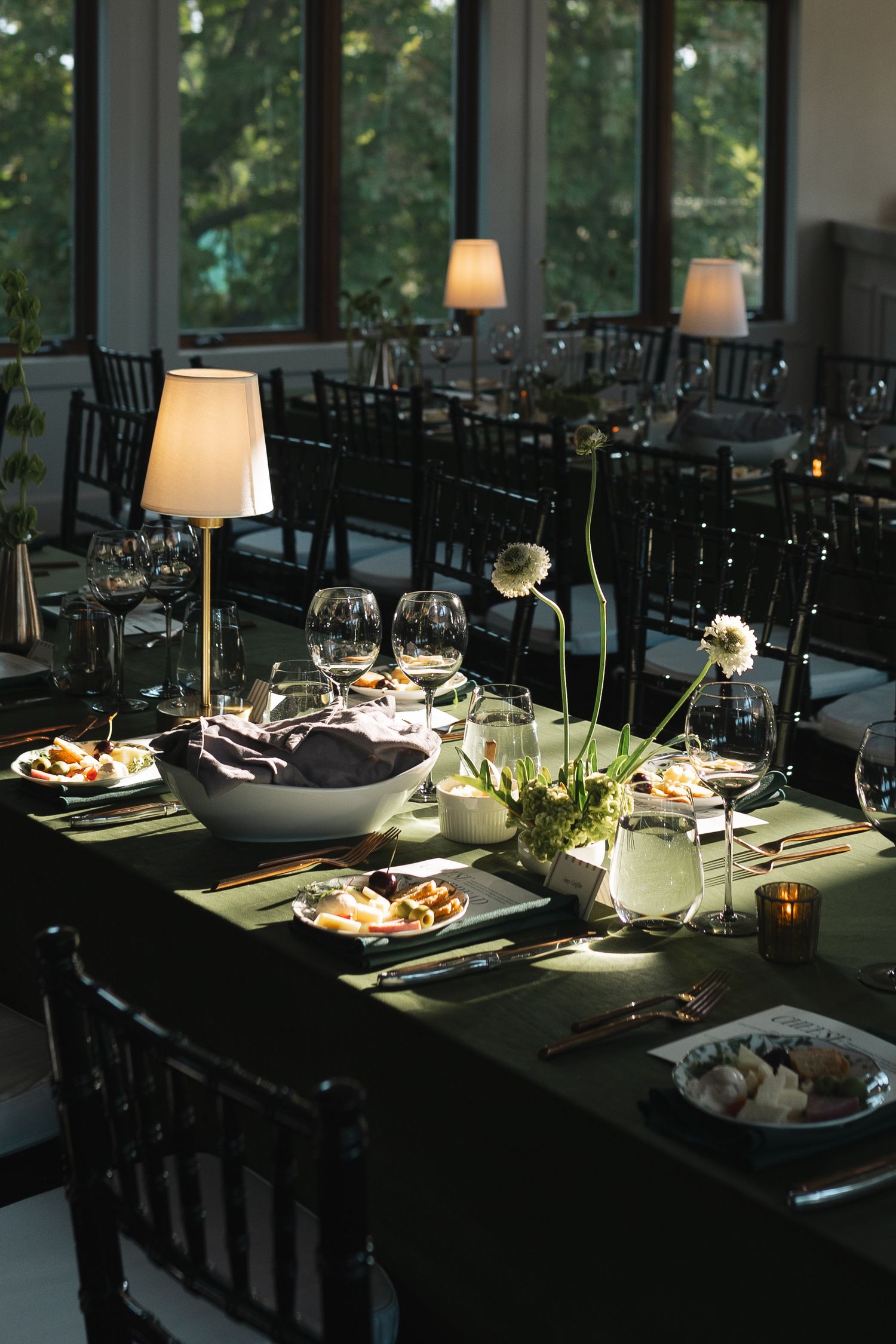 Elegant dinner table settings with wine glasses and ambient lighting in a modern venue interior.