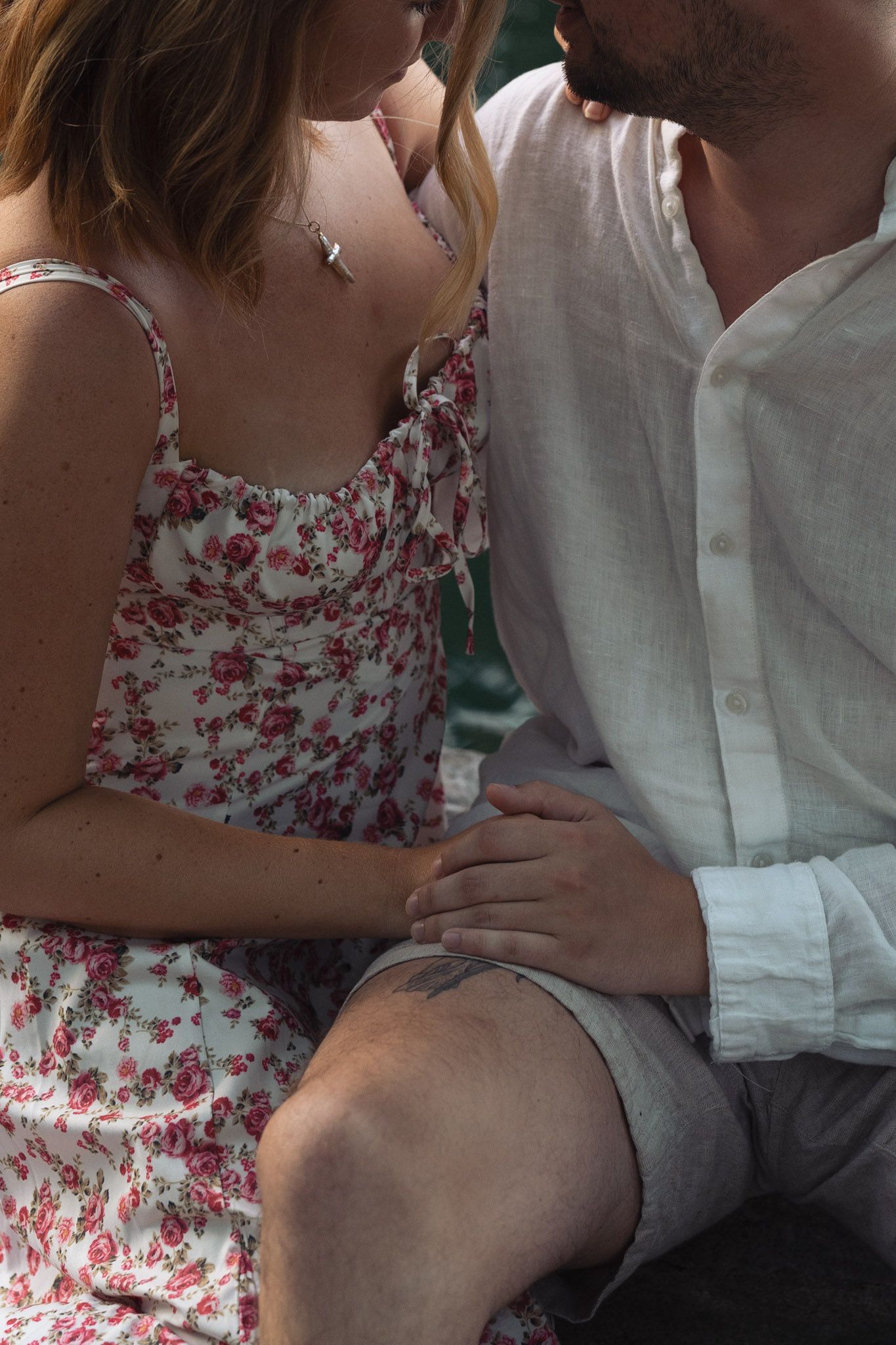 A couple in floral dress and white shirt sitting close together in Centennial Park in Nashville, Tennessee