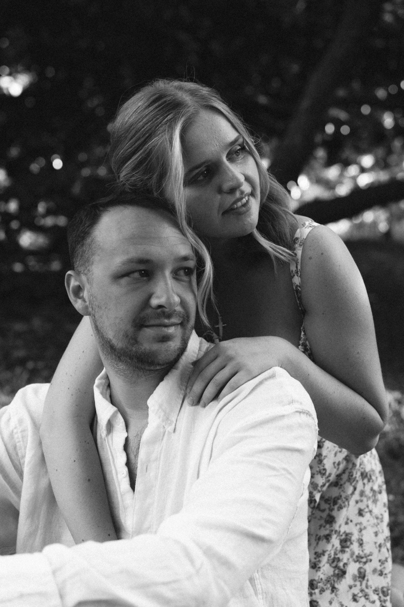 Black and white photo showing a couple in close embrace outdoors with a floral dress and white shirt in Nashville