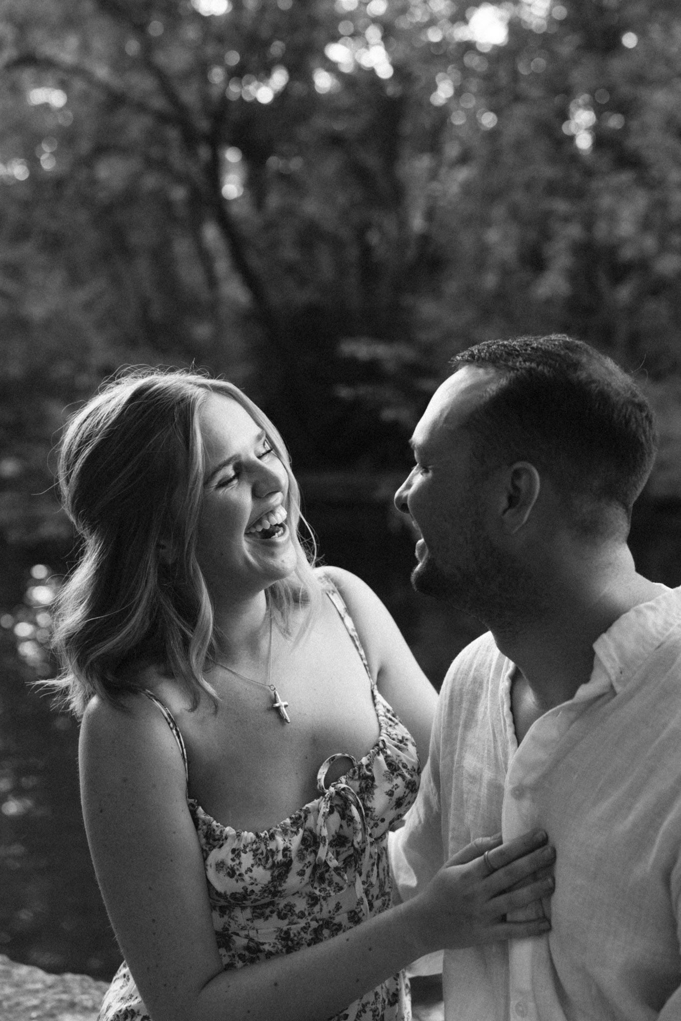 A romantic black and white photo showing a couple laughing and embracing in a natural outdoor setting in Nashville