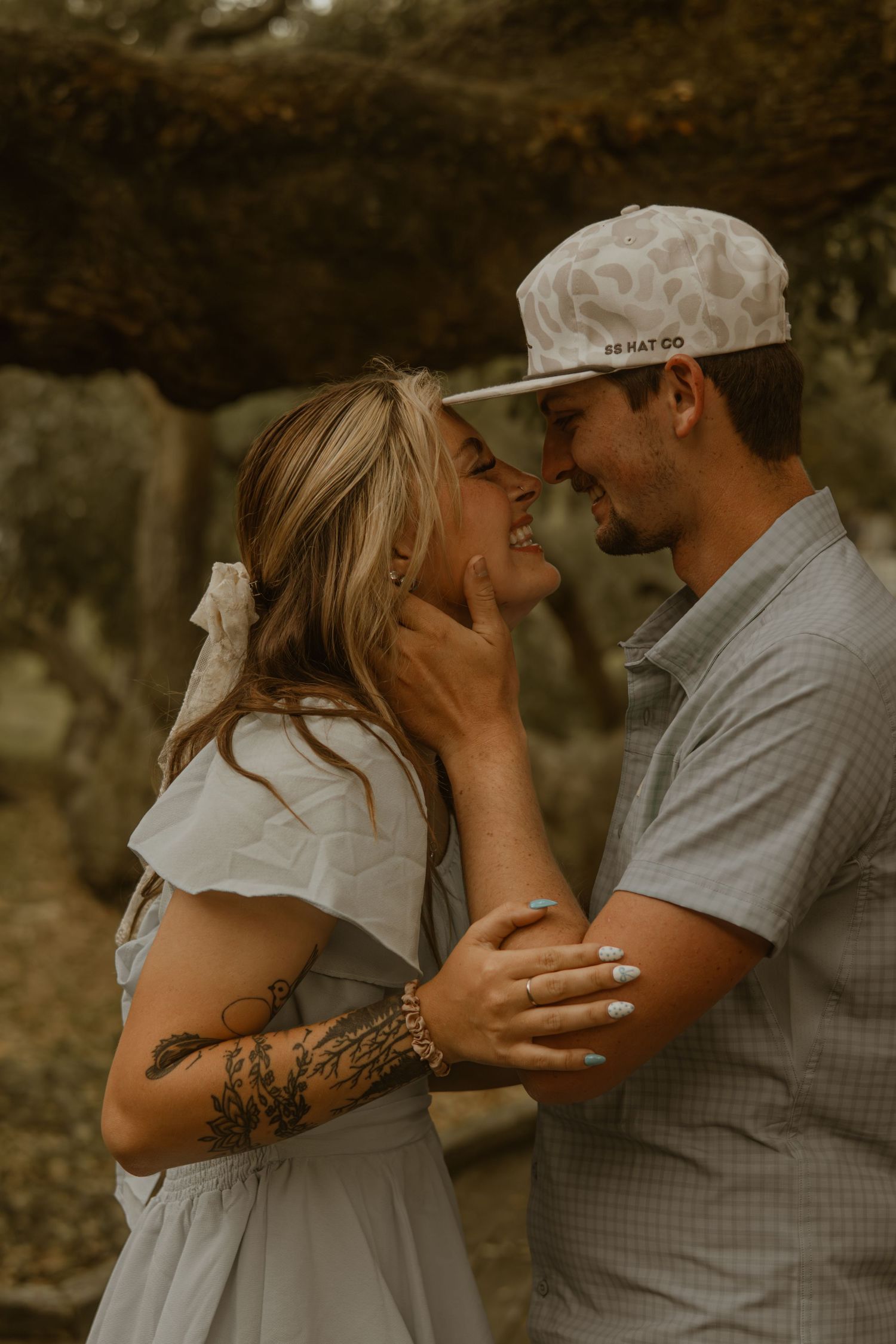 A couple in casual attire sharing a tender moment in soft natural lighting.