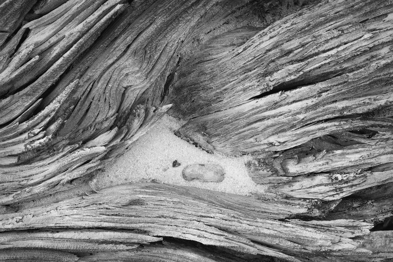 Abstract black and white patterns formed by natural rock formations create a dramatic swirling texture in stone.