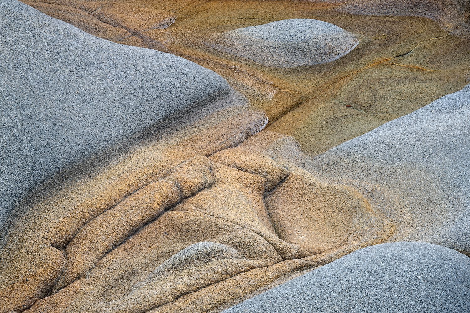 Abstract view of sandstone and water patterns creating natural curves and textures.