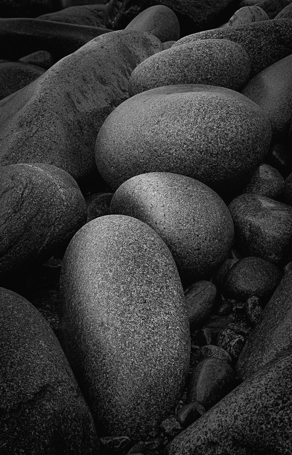 Black and white detail of smooth rounded rocks nestled together.