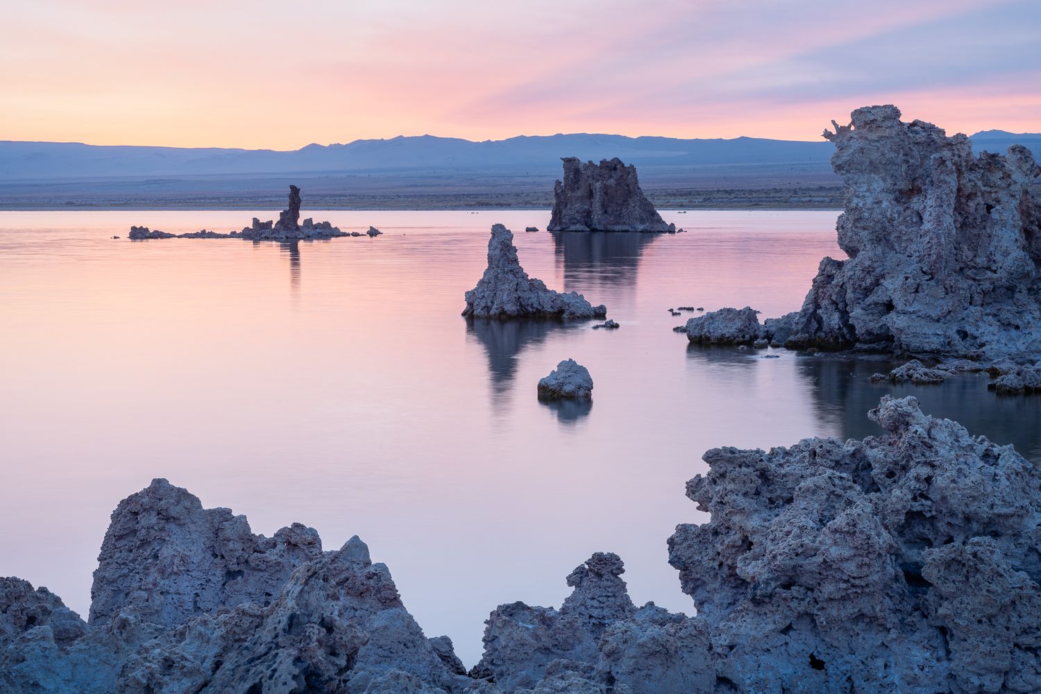 Mono Lake's tufa formations silhouetted against a pastel sunset sky.