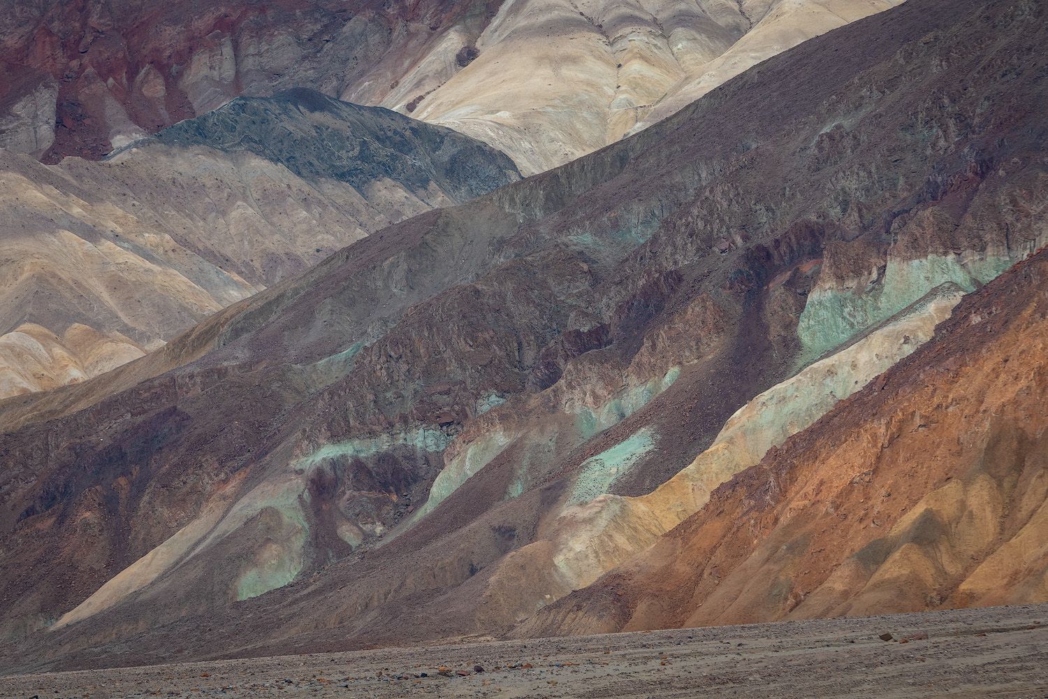 Colorful layered mineral deposits create a stunning geological palette across the rugged desert mountains of Death Valley.