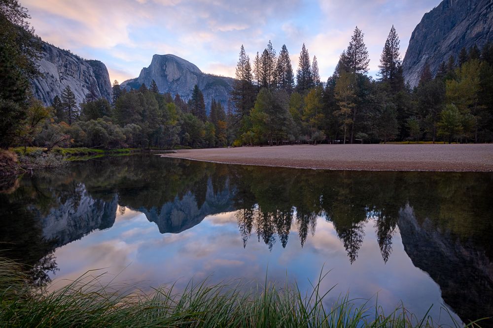 Half Dome reflected in the river at sunrise.