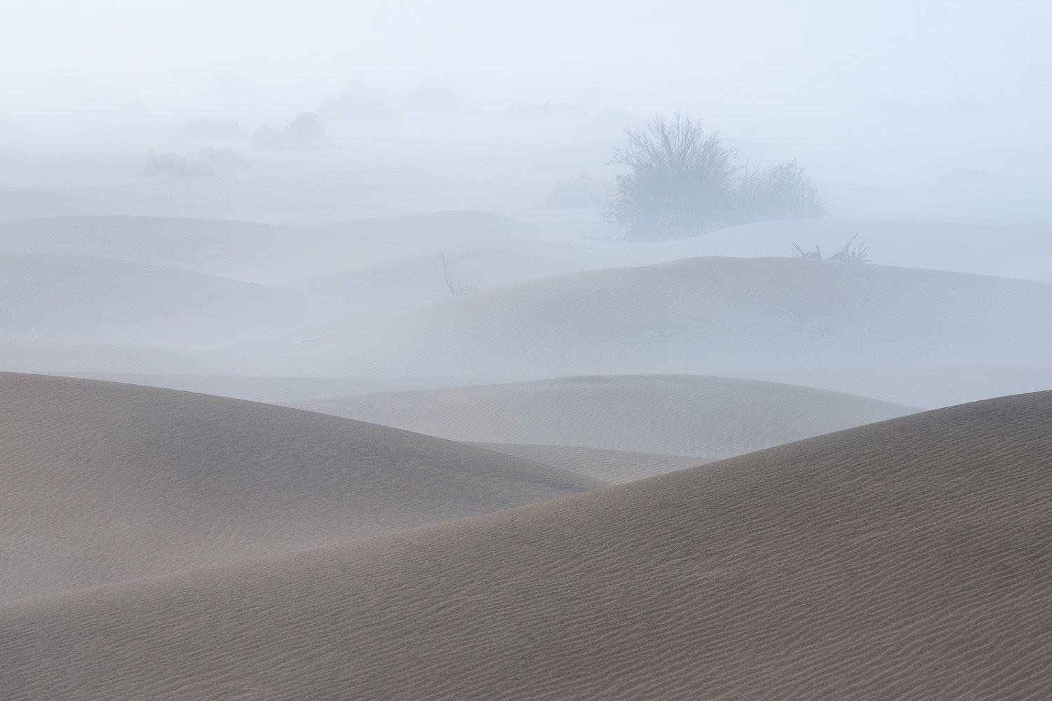 Rolling hills fade into misty mountains under an overcast sky creating a moody landscape view.