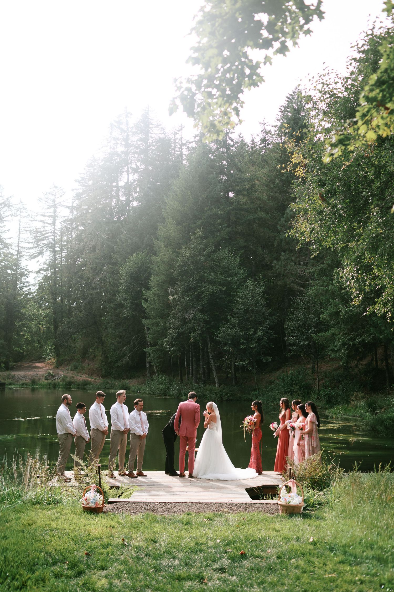 Wedding party gathered on a lakeside dock during an outdoor ceremony - Adrianna Elizabeth Photography.