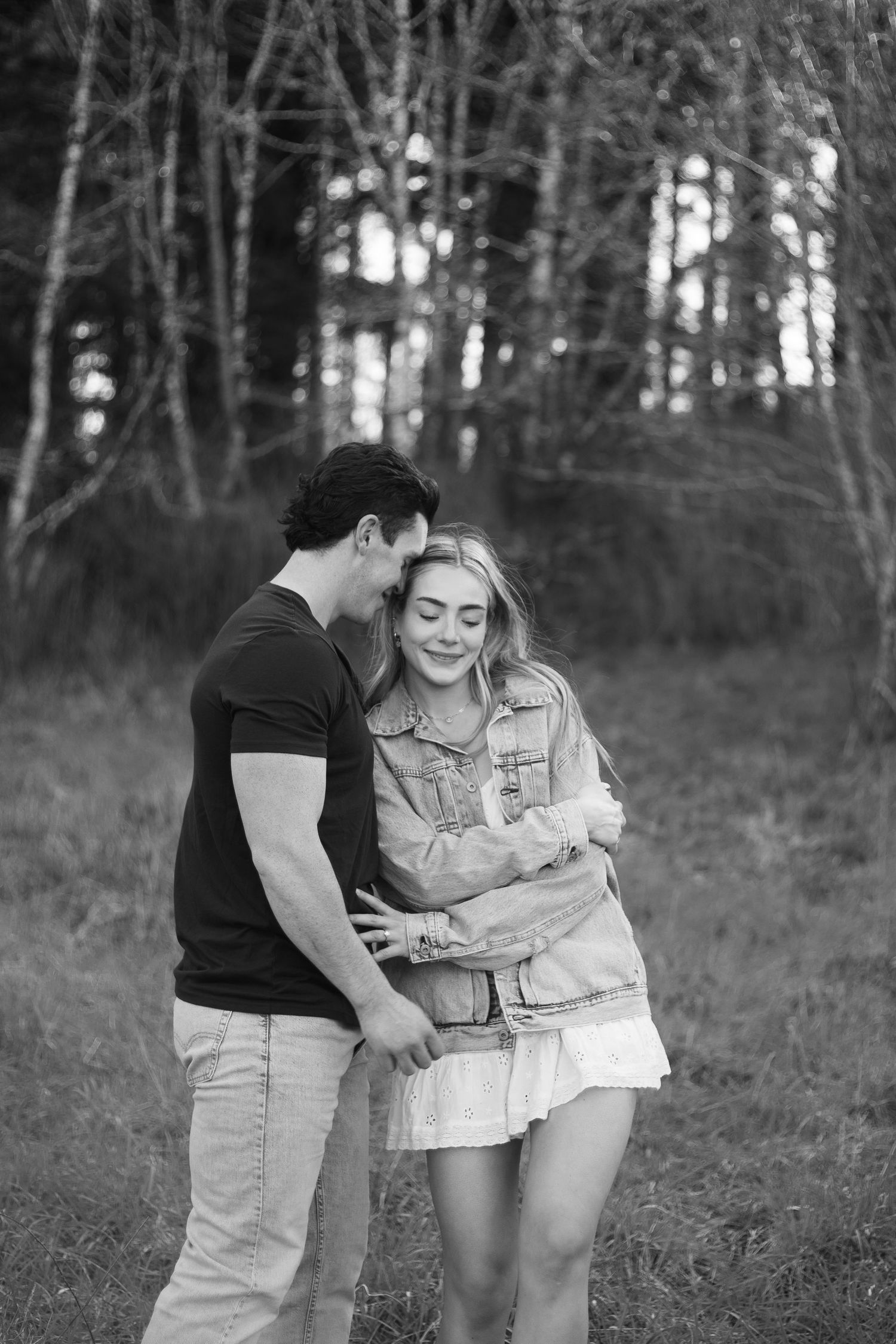 Engagement session candid moment shared between couple in black and white forest setting - Adrianna Elizabeth Photography.