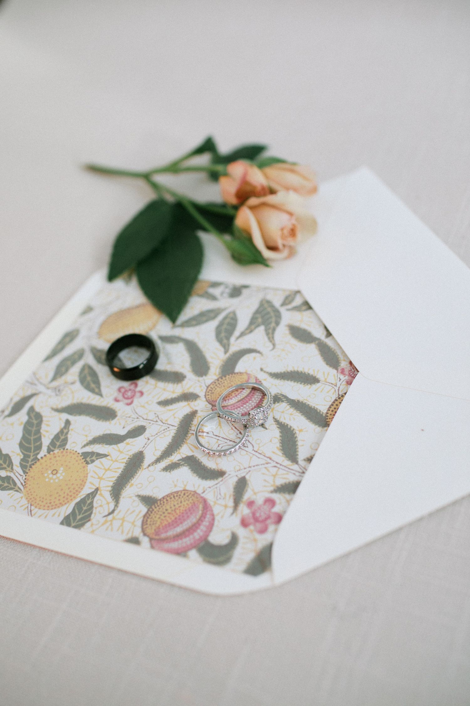 Delicate floral pattern on white paper with a peach rose and green leaf accent in a series of four artistic views.