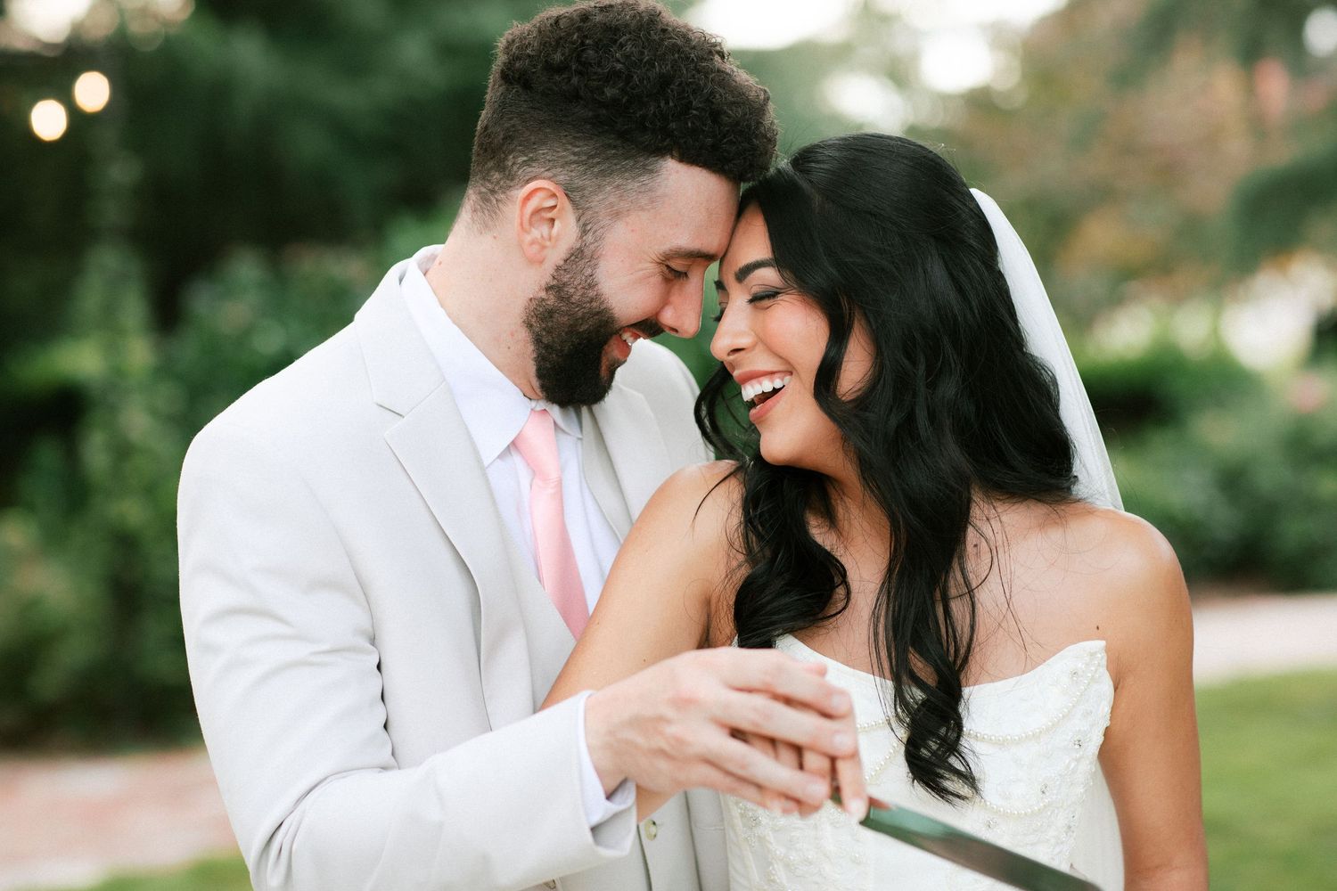 Romantic couple shares tender moments in a garden setting during golden hour photo session.
