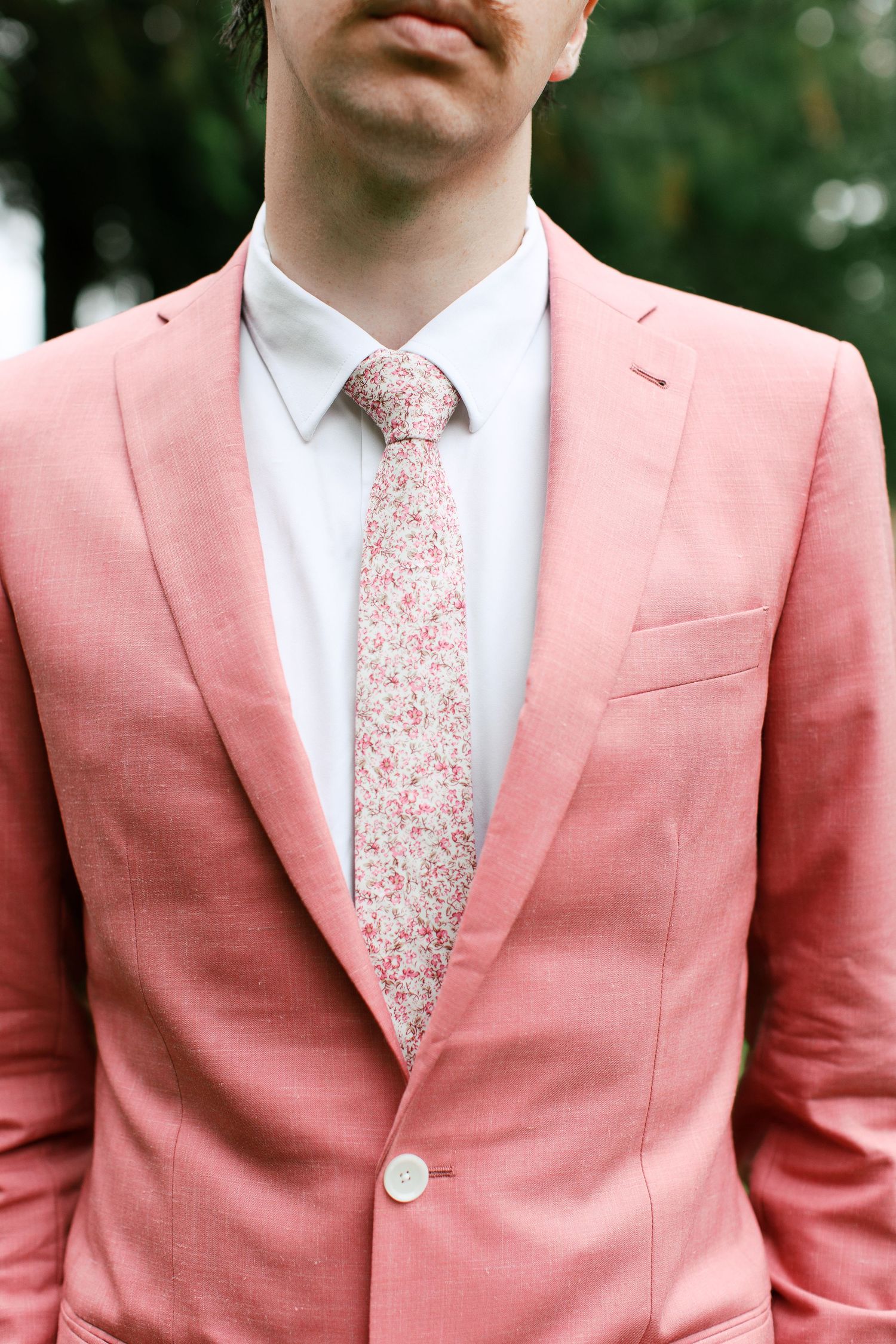 Groom wedding portrait wearing pink suit with floral ties with Adrianna Elizabeth Photography